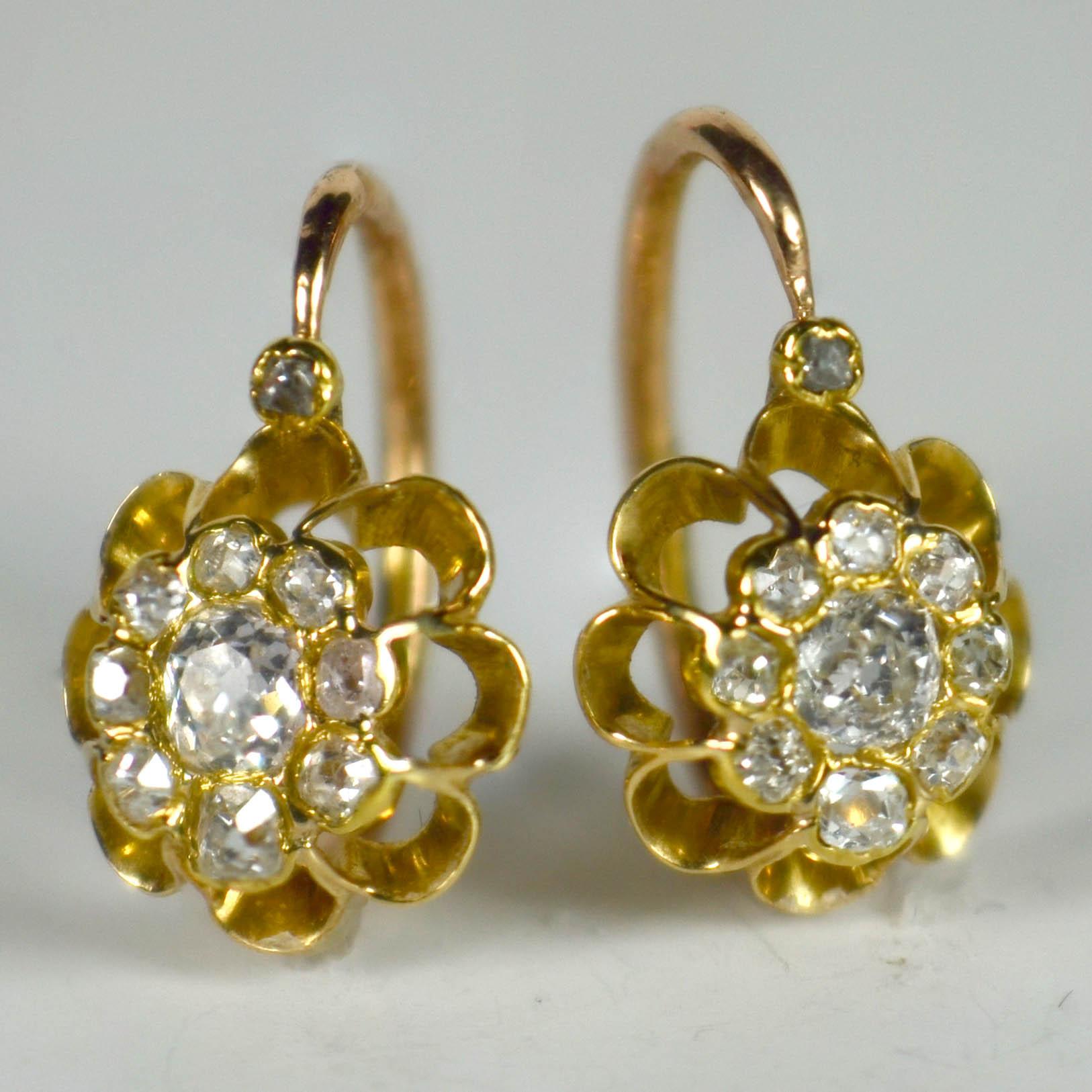 A pair of French 18 karat rose and yellow gold 'dormeuse' cluster earrings set with 20 diamonds in a floral design. These drop sleeper style earrings are immensely wearable with bright white diamonds cut in the Old Mine Cut style.

Unmarked, but