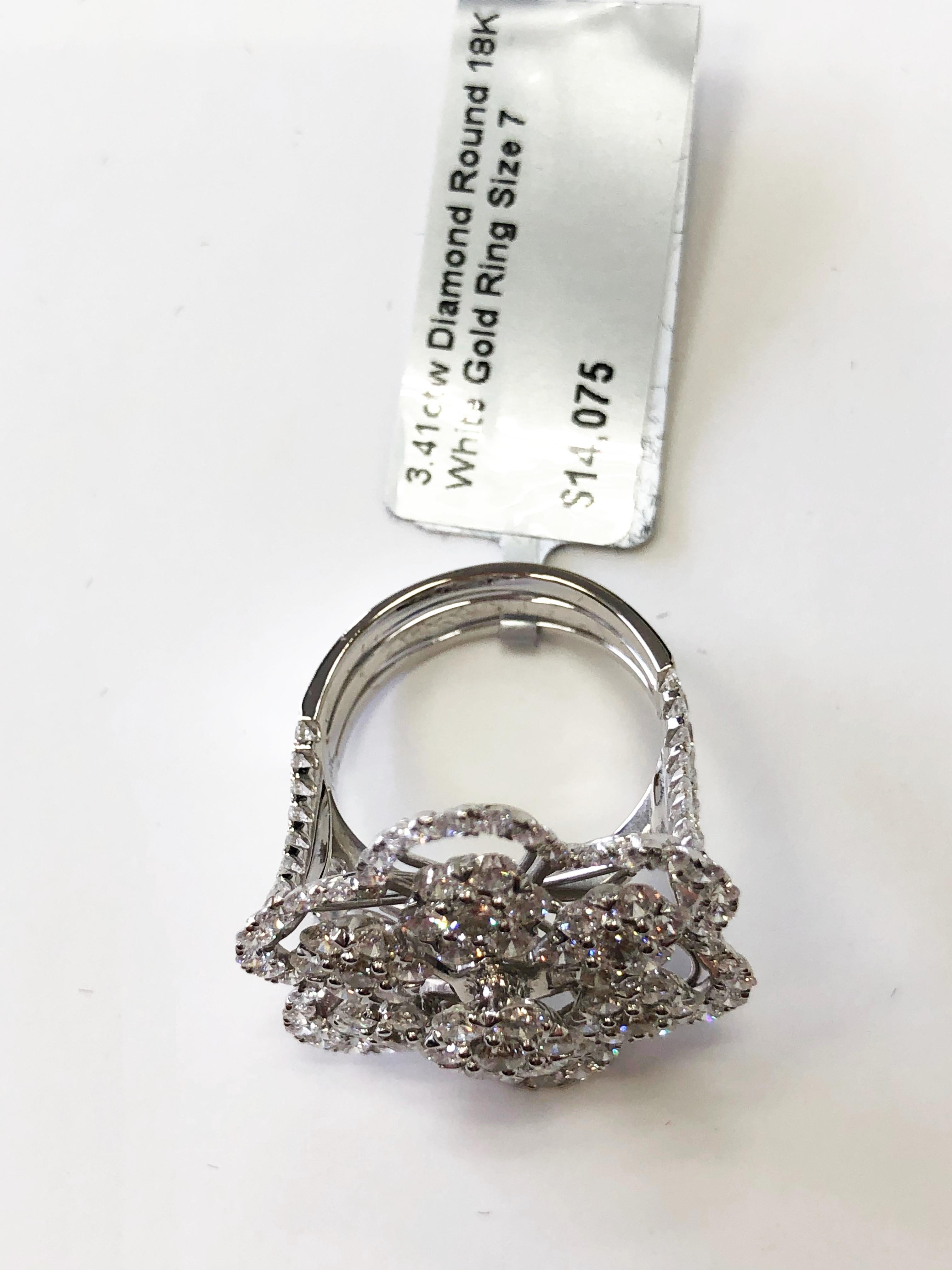 Gorgeous white diamond round floral cocktail ring in 18k white gold.  There are 3.41 carats of bright, white, good quality diamond rounds that are invisible set to make them look like they are bigger single stones.  Very well made so that there is