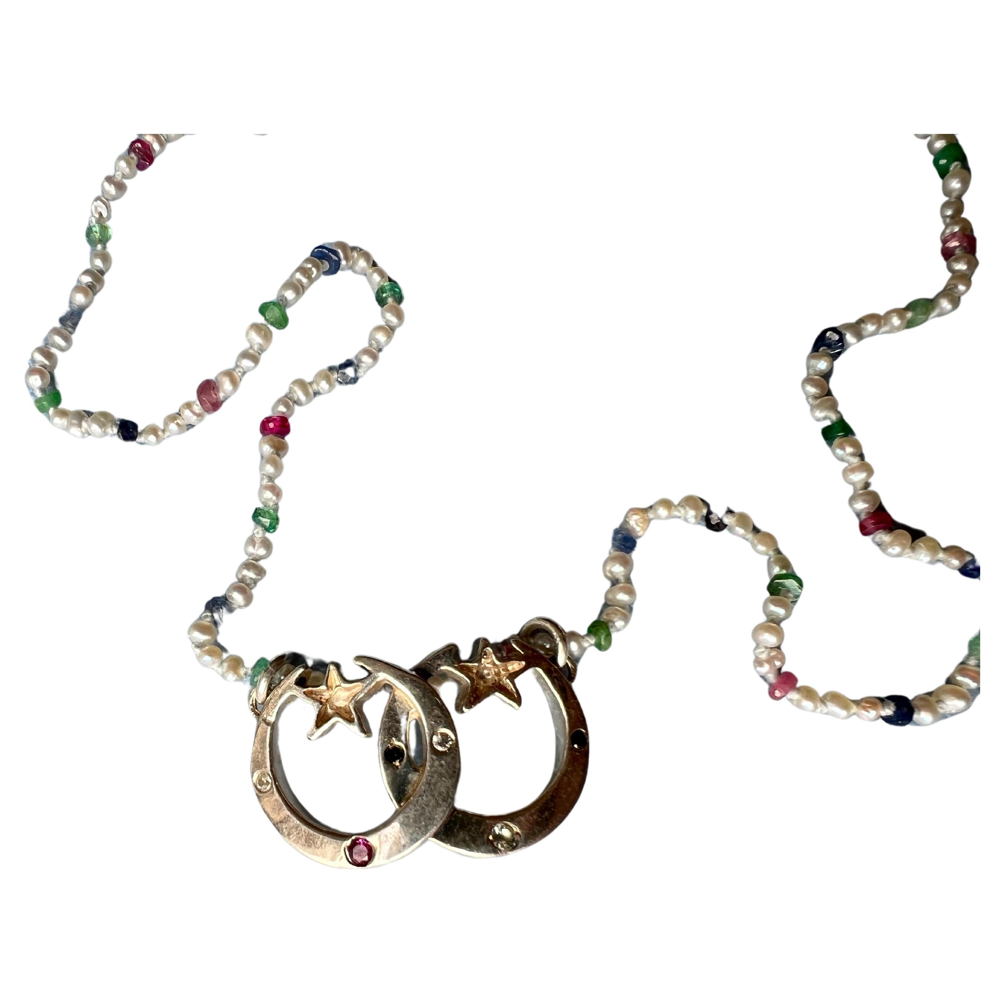 Double Crescent Moon Star Necklace with White Pearl Ruby Blue Sapphire and Emerald Choker 

The crescent moons are also studded with several gems Ruby, Aquamarine and possibly White Diamond and Black Diamond.

Pearl necklace is 38 cm

Hand made in