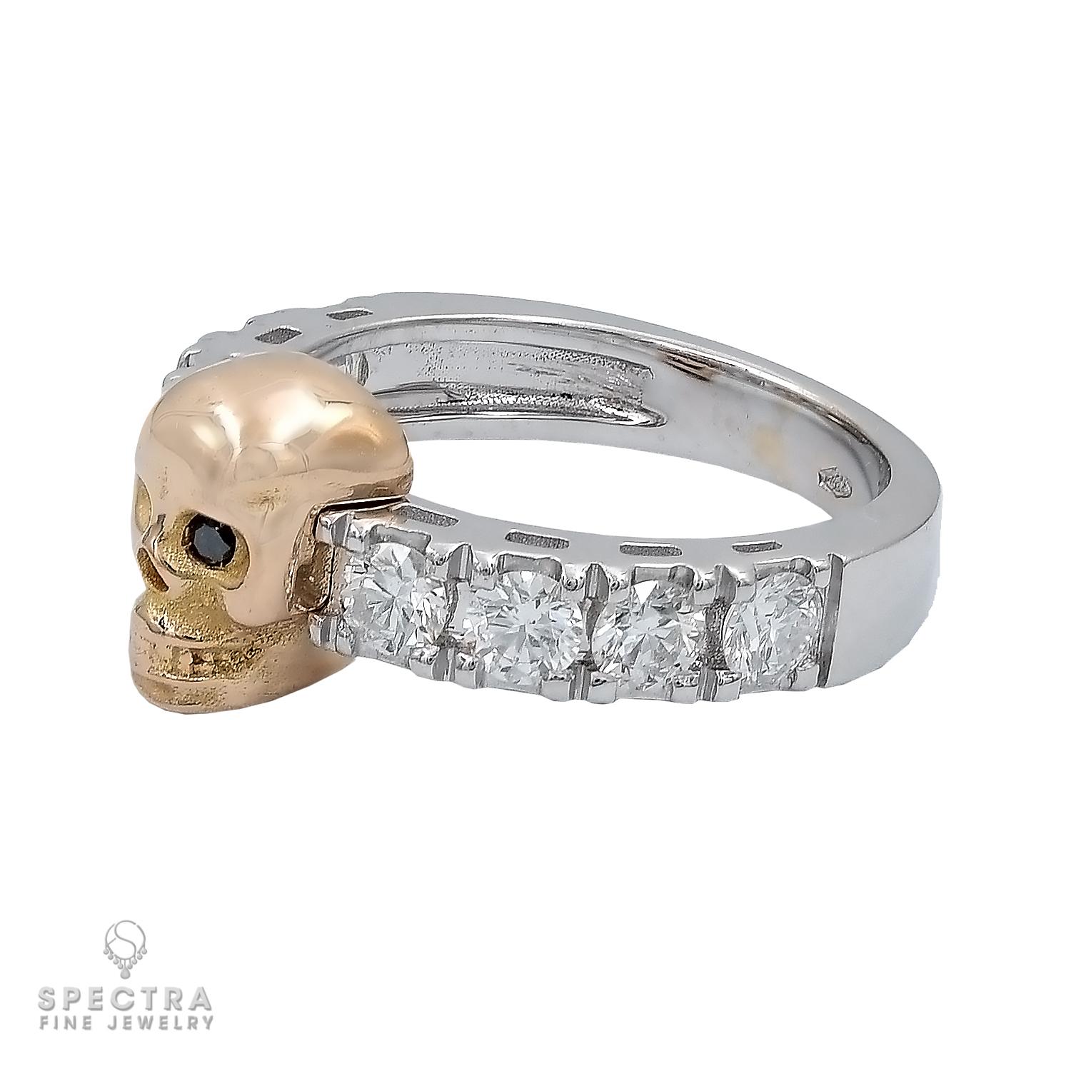 The Round Diamond Skull Ring features a rose gold skull with black diamond eyes. Eight round diamonds totaling 1.20 carats encircle the skull. 
It is crafted on an 18k white gold base and weighs 6.18 grams. 
Size 6.5. The ring cannot be resized.
