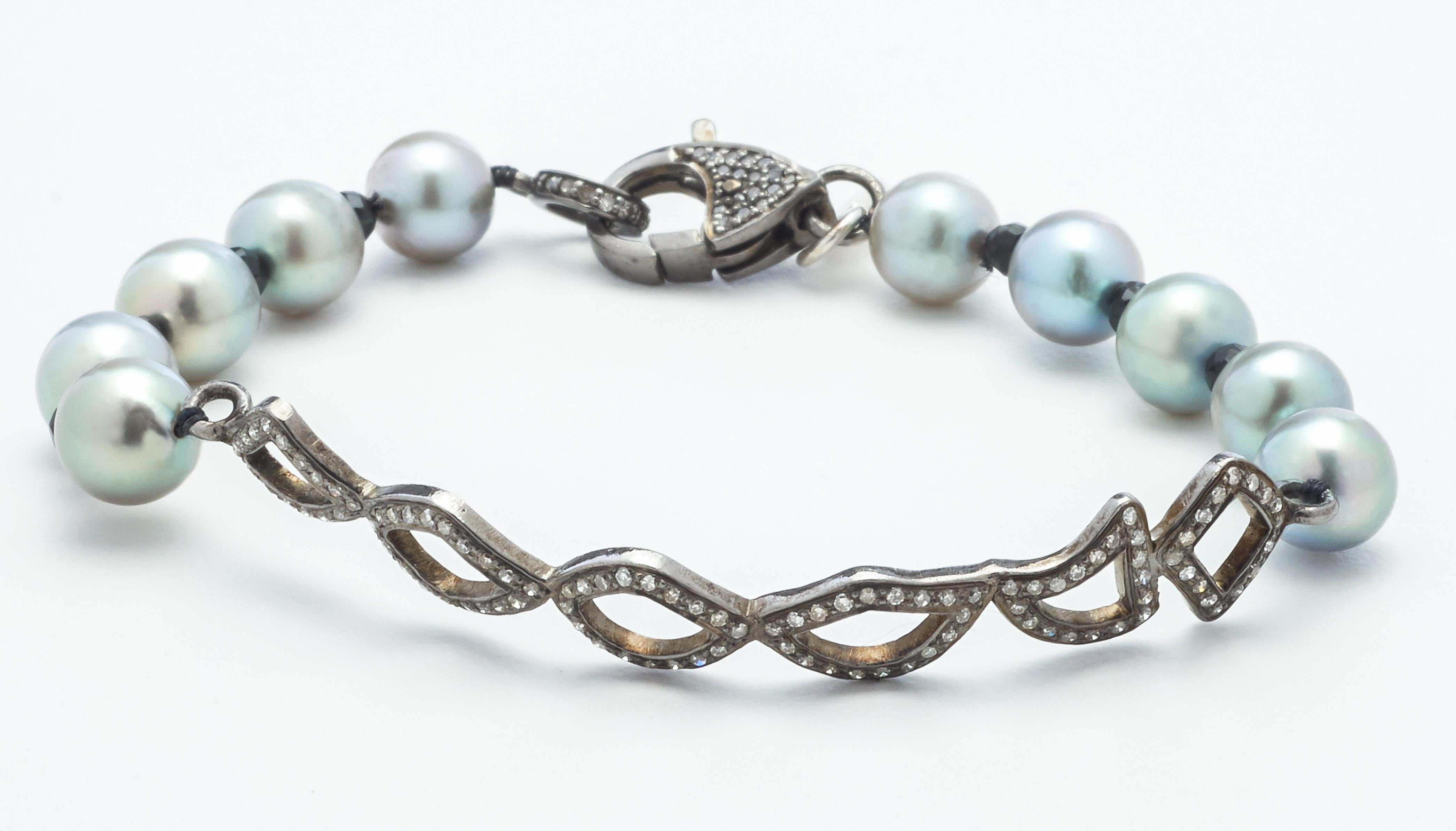 An artisan original, this 7 inch bracelet features natural Akoya pearls that are colored in a cool blue gray, hand-strung with natural black spinel beads that truly compliment the featured diamond covered 2-1/2 inch sterling silver bar placket