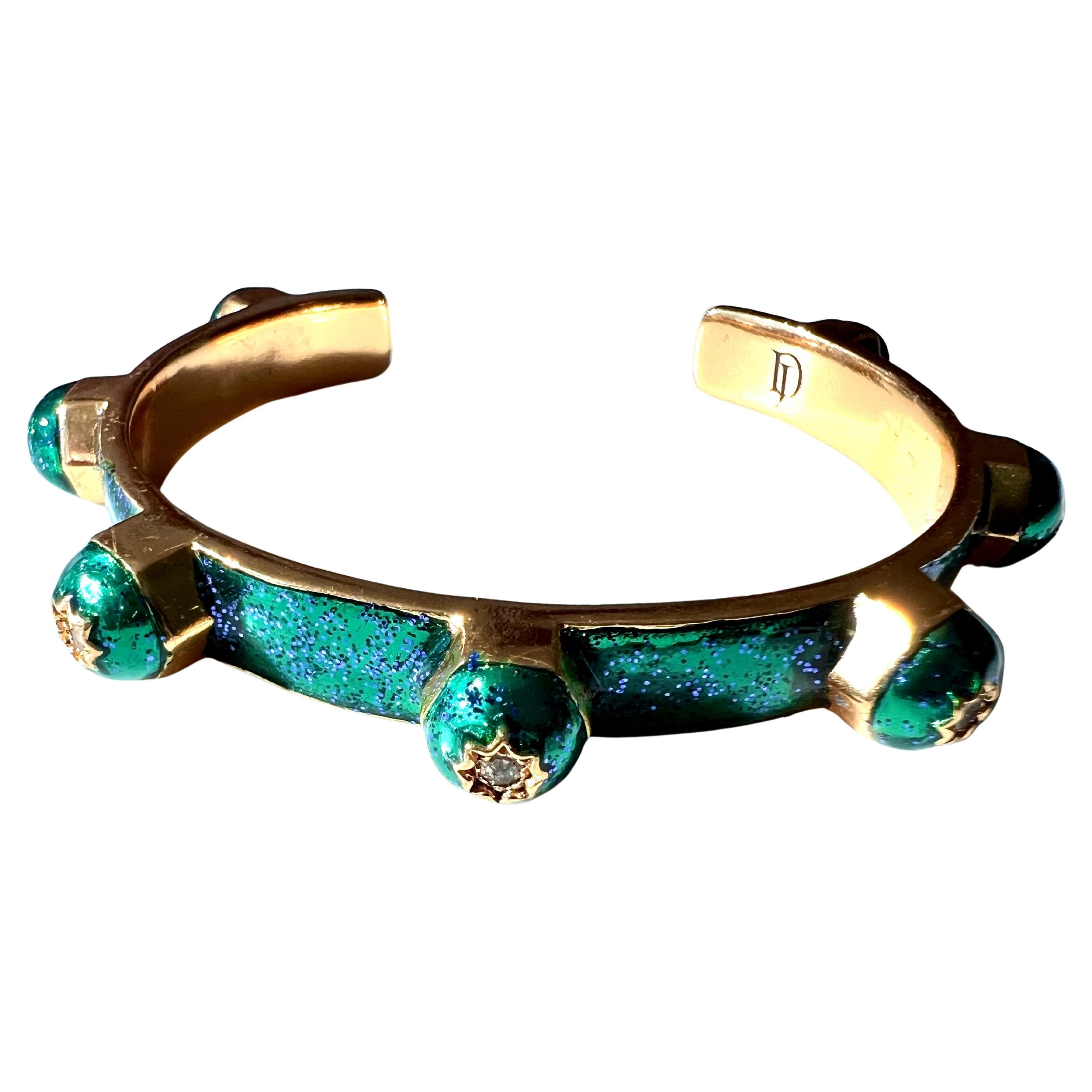 Sieben weiße Diamanten in einem achtspitzigen Stern auf jedem Bolzen dieses Manschettenarmbands, handbemalt mit grüner Glitzeremaille. Inspiriert von Schmuck im viktorianischen Stil.

Designer: J DAUPHIN

Diamanten werden oft mit tiefgreifenden