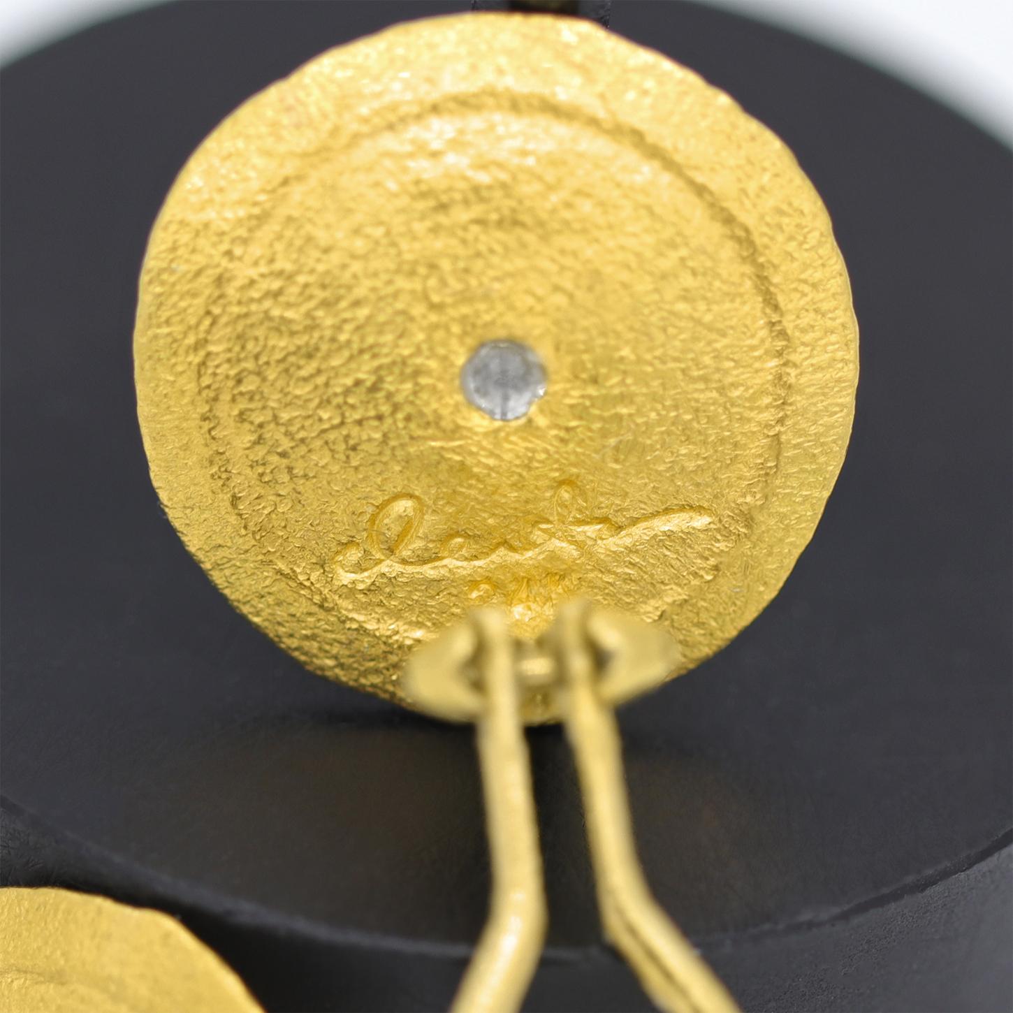 Les clous d'oreilles soleil de Devta Doolan, joaillier renommé, sont fabriqués à la main en or jaune pur 24 carats à la texture complexe, rehaussés d'une paire de diamants blancs ronds de taille brillant F/vs1 et montés sur des clips en or jaune 18