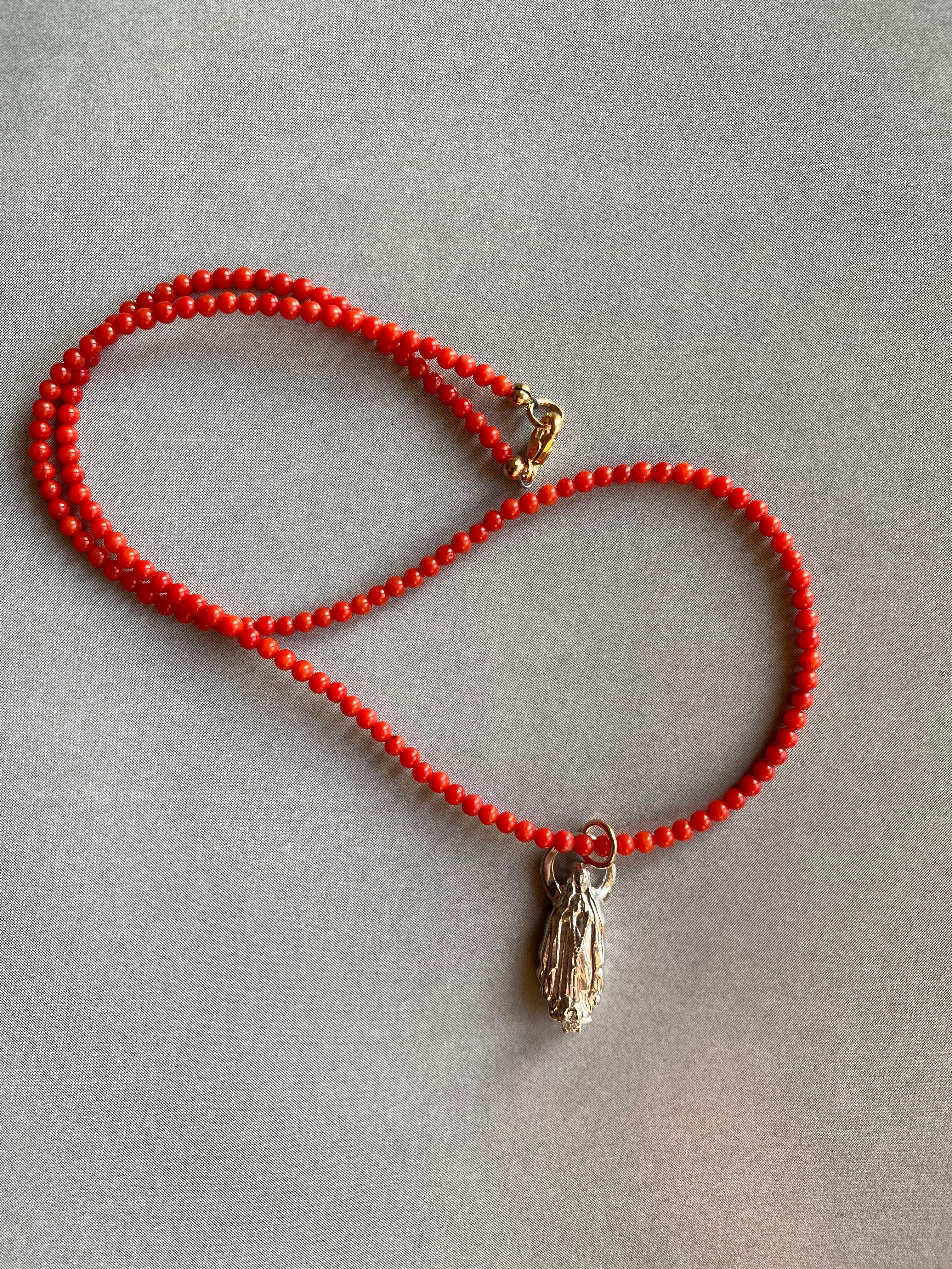 White Diamond Virgin Mary Medal Red Coral Choker Necklace 

Designer: J Dauphin

Exclusive piece with Virgin Mary Medal with a White Diamond set in a gold prong. Bead Necklace is 16' long but can be made shorter or longer on request.

Made in Los