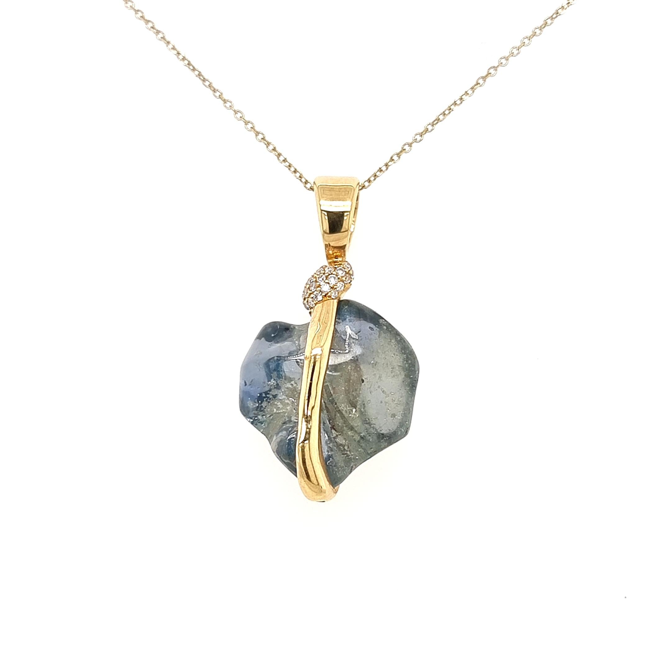 Collectional de VOTIVE.

Bienvenue dans la captivante Collection S de VOTIVE, qui présente un pendentif en or jaune 18 carats, orné de brillants diamants ronds blancs et couronné d'un saphir bleu central envoûtant. Ce saphir bleu non taillé, mais