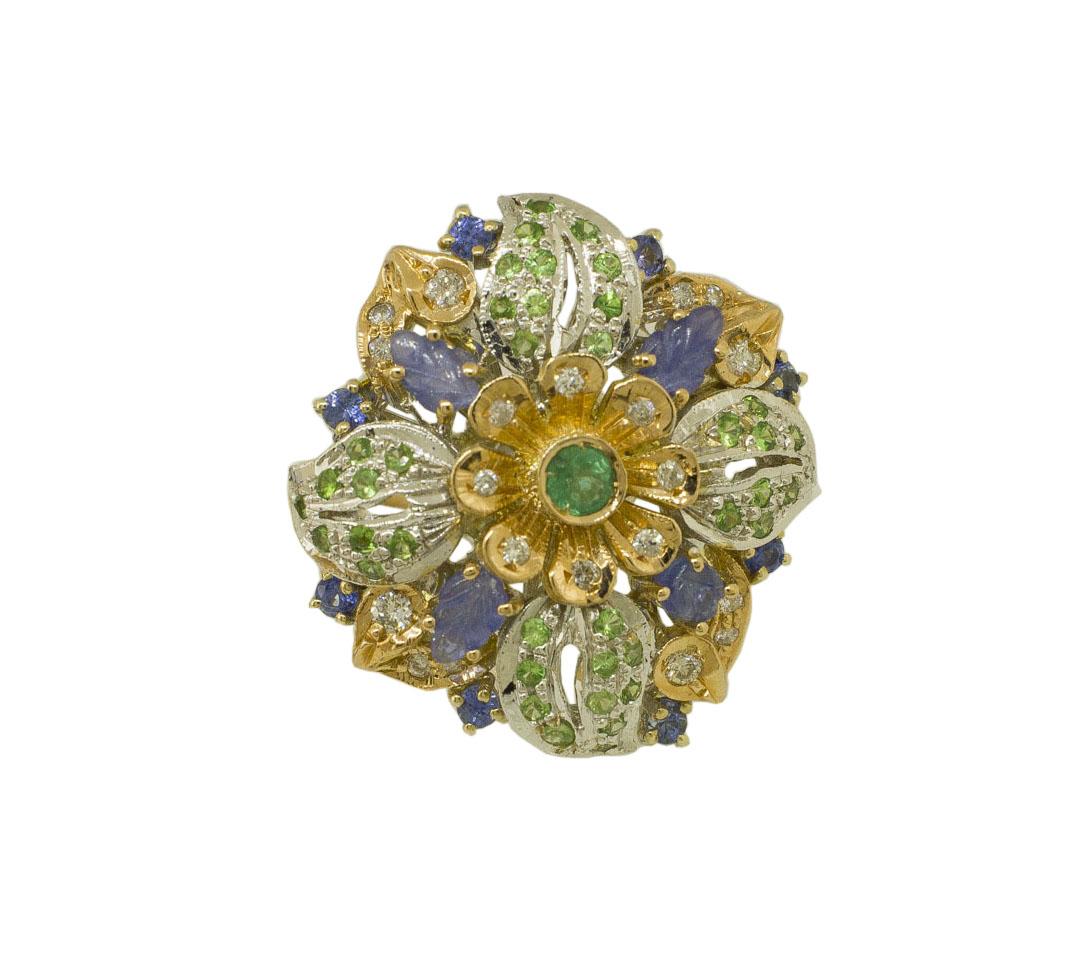 Gorgeous flower shape fashion ring in 14K white gold structure, composed by rose gold flower in the center with white diamonds on the petals and one green emerald in the center; around there are 4 blue sapphires leaves shape, 14K white gold leaves