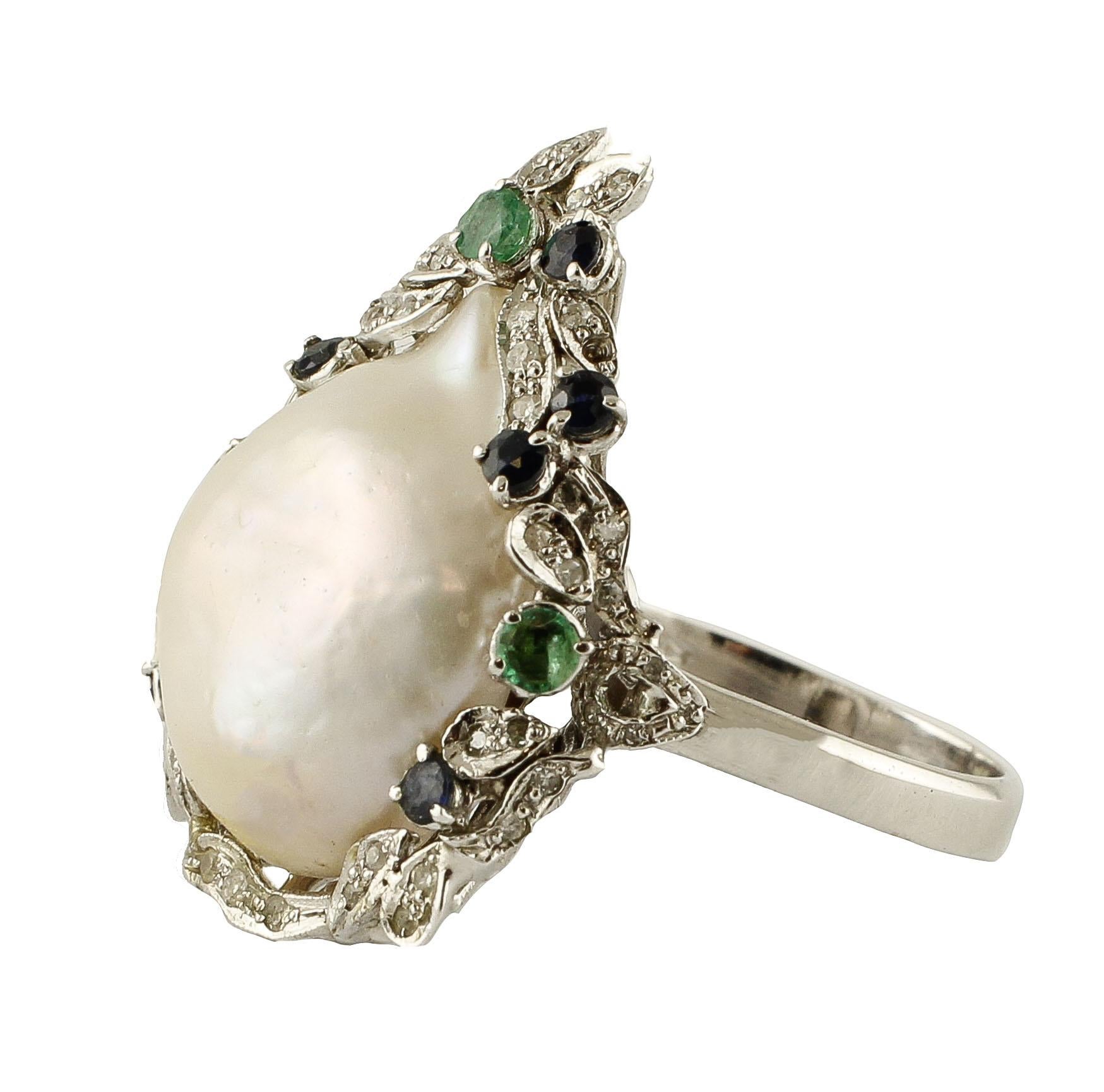 Unique drop shape cocktail ring in 14K white gold composed by one glossy drop shape baroque pearl in the center surrounded by 14K white gold details all studded by little white diamonds and adorned by little emeralds and blue sapphires
Diamonds 0.49