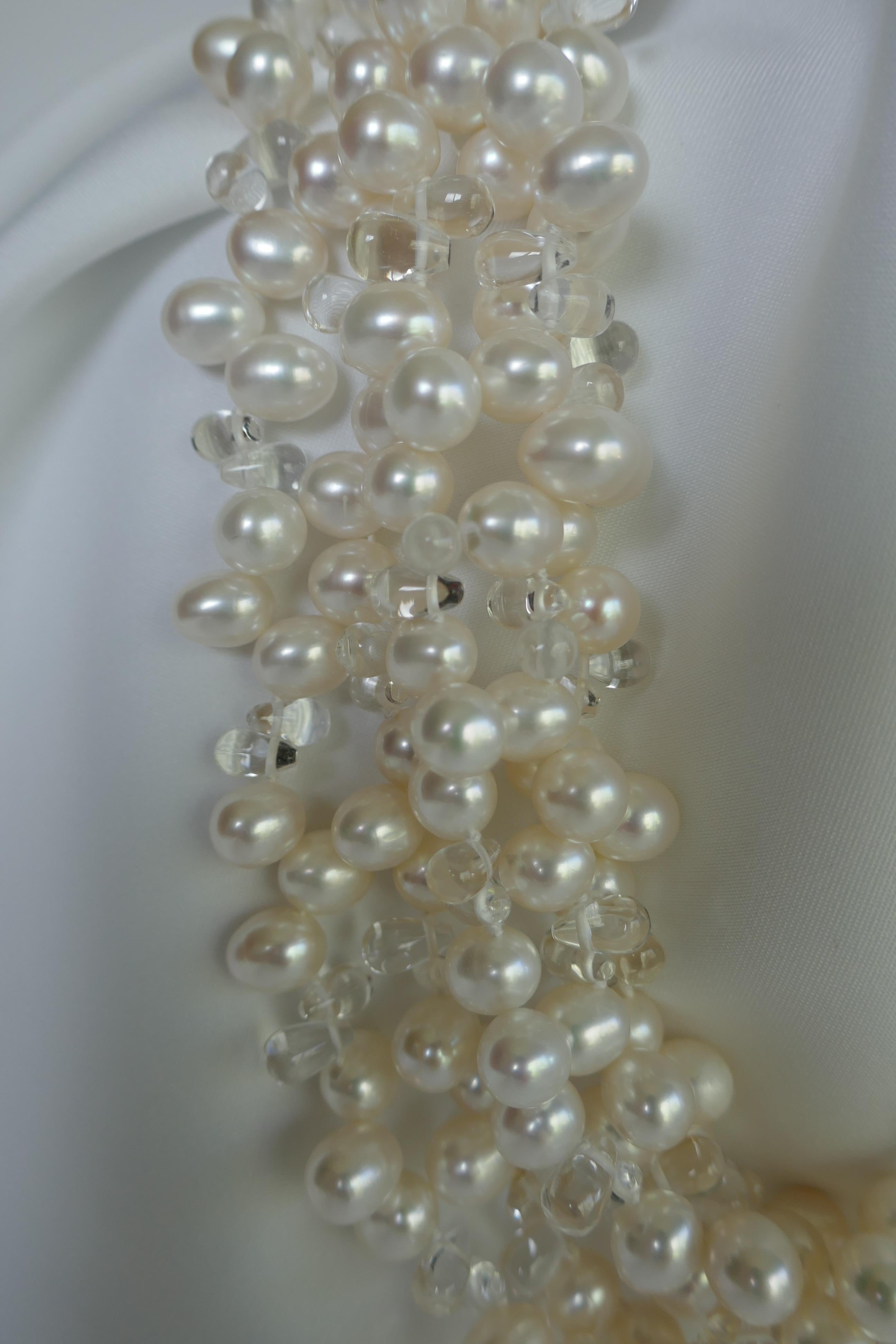 This is a five strand white cultured drop pearl necklace interspersed with rock crystal briolettes with a 925 sterling silver clasp. The cultured pearls are 8.5mm-9mm. The pearls have great luster and very little blemishes. It is strung on white