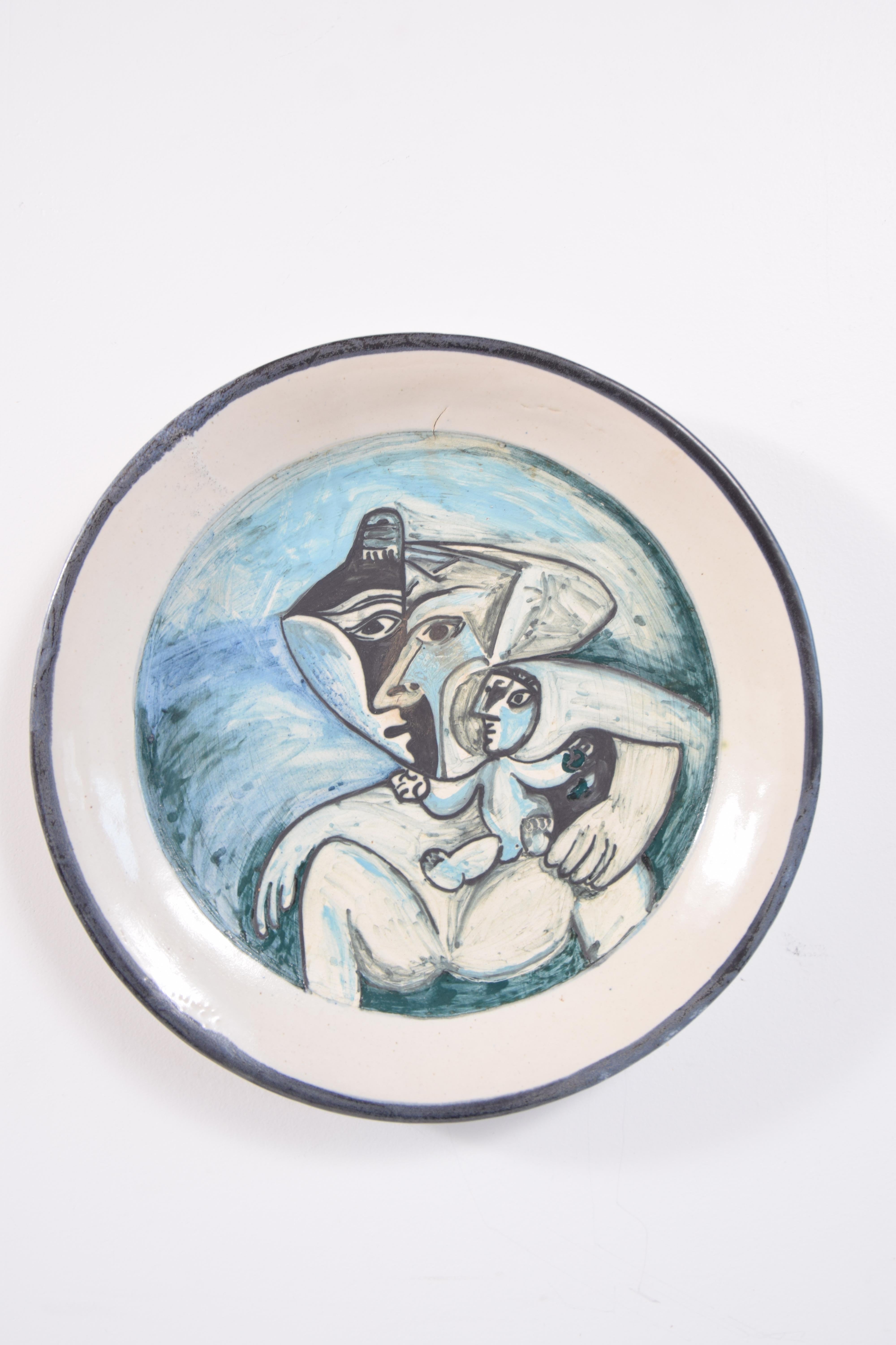 White earthenware ceramic Charger, circa 1970, signed Picasso. Although signed Picasso, this piece is not signed Madoura, and as far as we can tell, all authorized Picasso ceramic pieces were produced by Madoura. Charger has two small holes on the