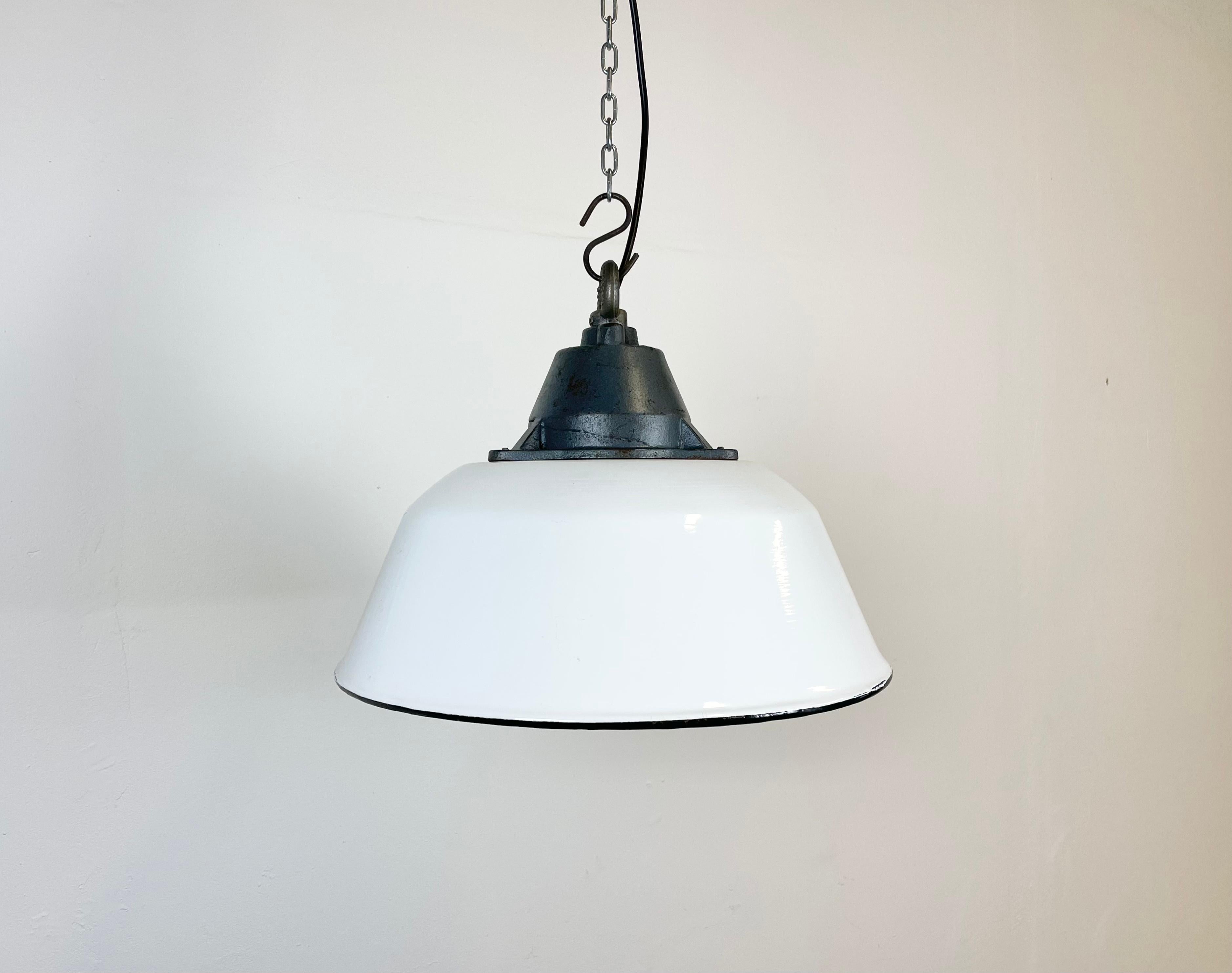Industrial hanging lamp manufactured by Szarvasi Vas - Fém in Hungary during the 1960s. It features a white enamel shade, white enamel interior and grey cast iron top. New porcelain socket requires E 27 light bulbs. New wire. The diameter of the