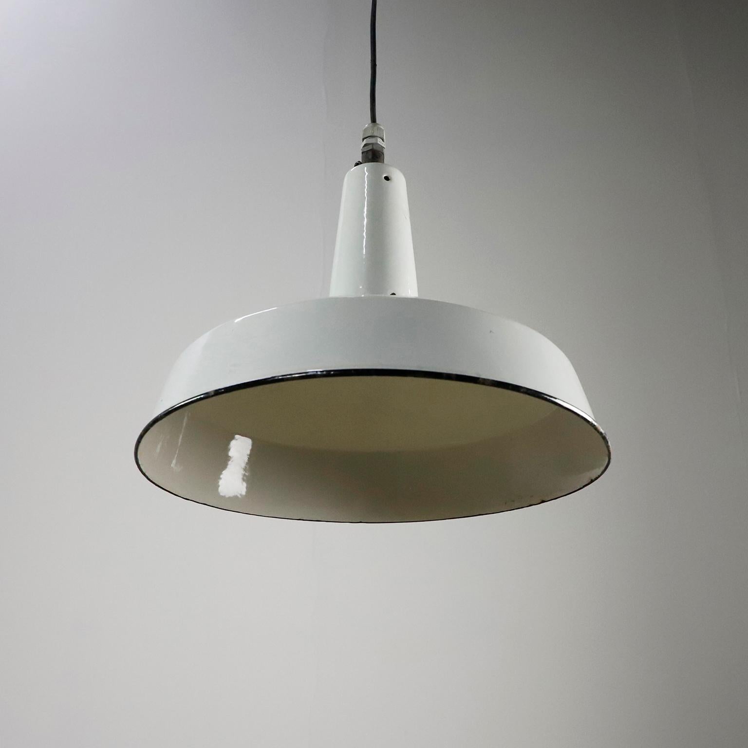 Circa 1960 . Offriamo questo set di tre luci a sospensione industriali in ghisa e smalto bianco.