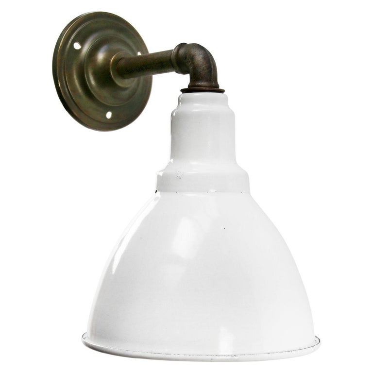 Factory wall light
White enamel shade, cast iron arm and brass wall plate

Diameter cast iron wall piece: 10 cm, 2 holes to secure

Weight: 1.80 kg / 4 lb

Priced per individual item. All lamps have been made suitable by international