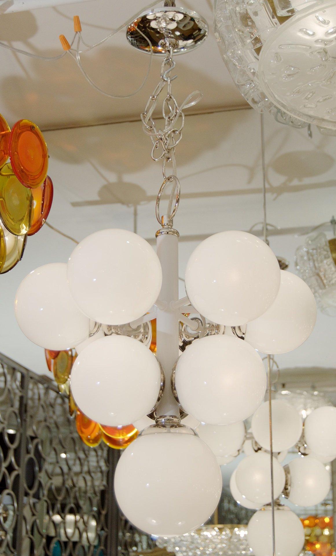 Spain, 1960s

A pyramid form white enameled chandelier with chrome accents and gloss opal globes.

Takes 10 E-14 base bulbs up to 40 watts per bulb, new wiring.

Height listed is of chandelier body only, chain length adjustable