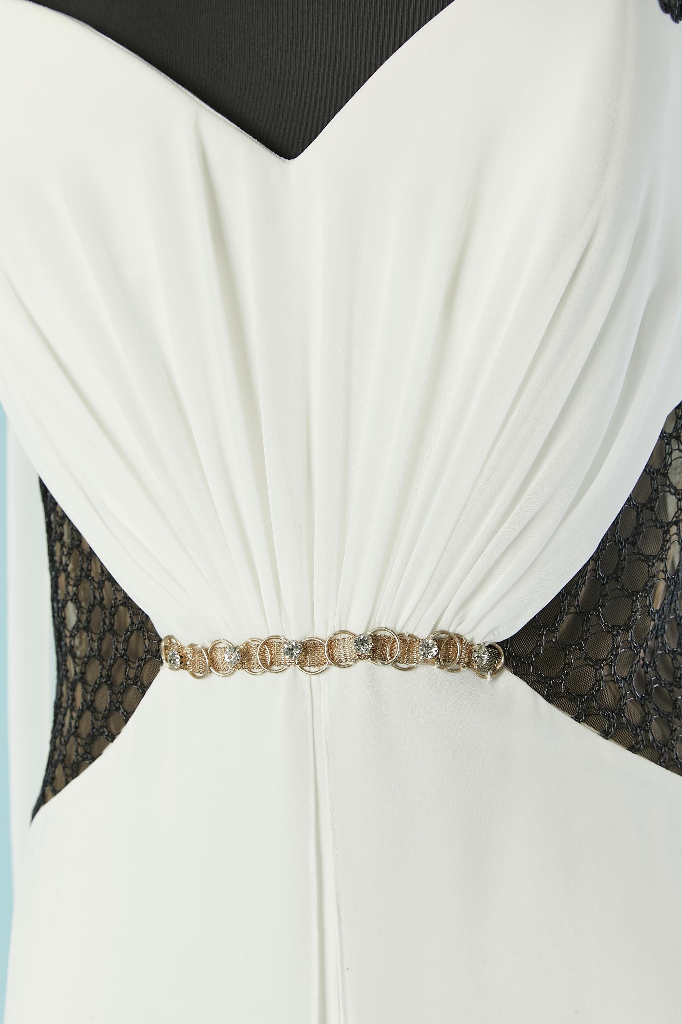Combinaison de soirée blanche avec broderies et transparences en tulle et dentelle. 
Pas d'étiquette de marque. Composition du tissu principal : 95% polyester, 5% élasthanne. Dentelle et broderies en nylon noir transparent. Fermeture éclair