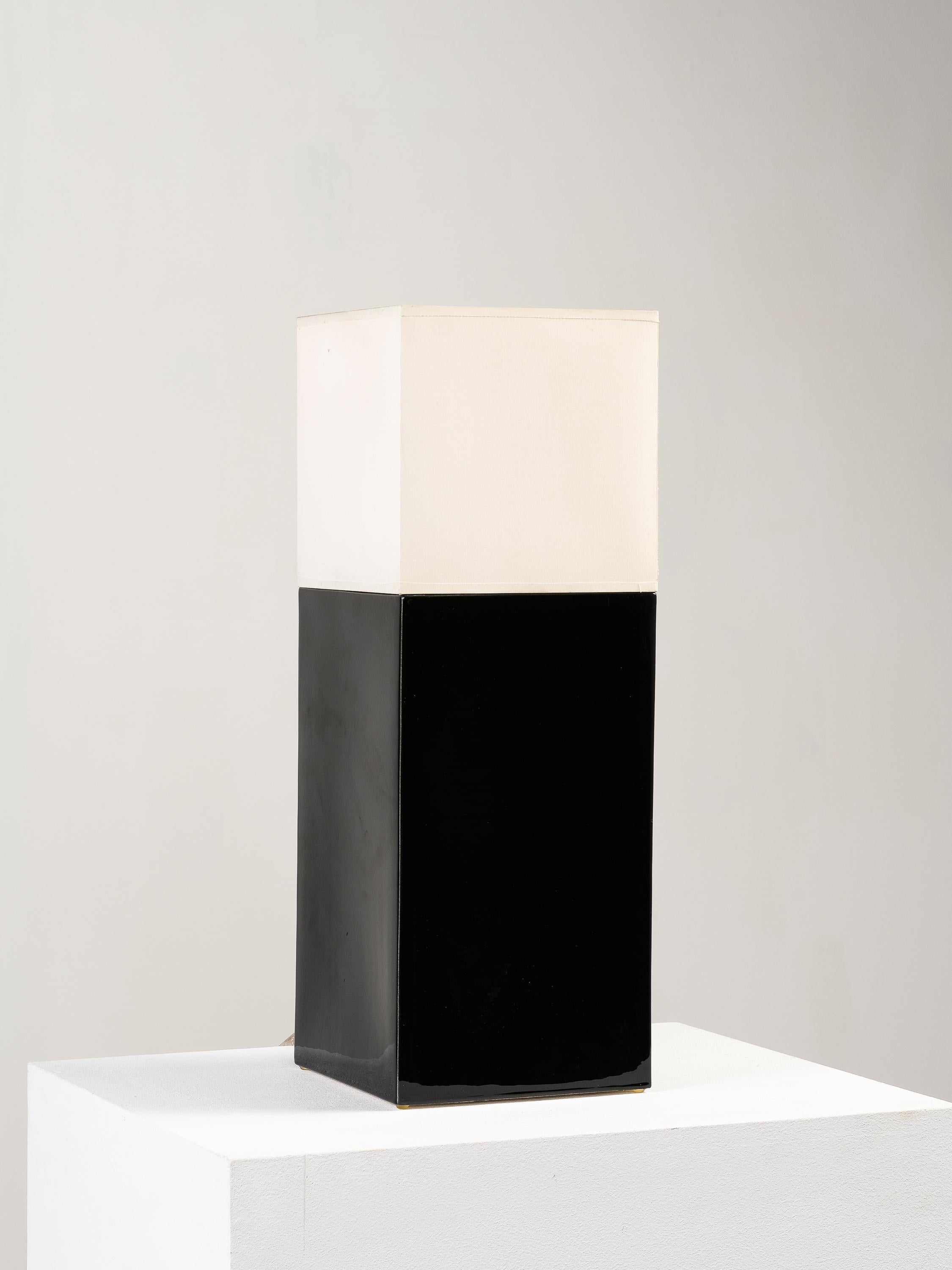A striking study in contrast and form, this ceramic table lamp by Faïencerie de Charolles was crafted in France during the 1980s. The design is defined by its bold, architectural silhouette—featuring a sleek, high-gloss black ceramic base with