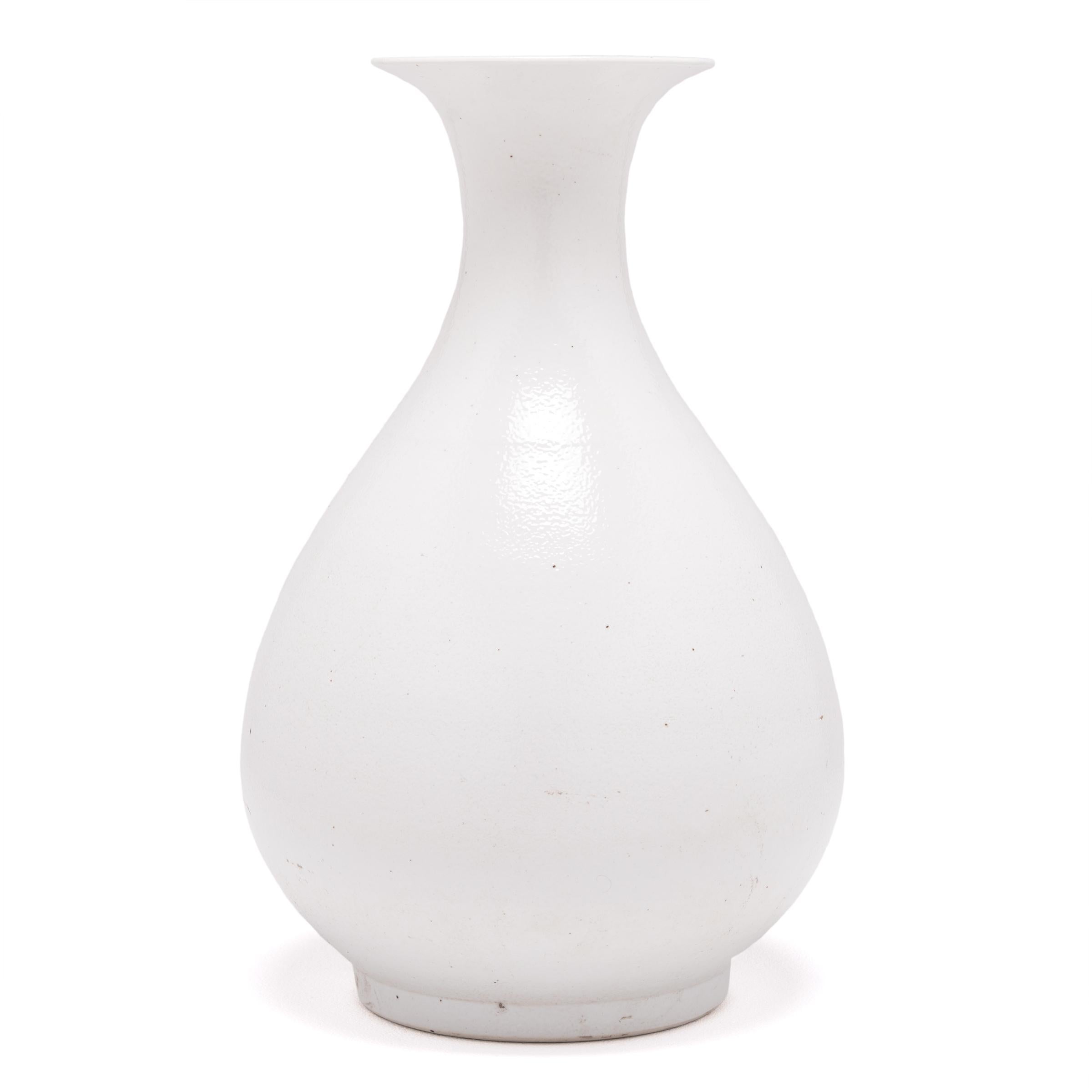 Drawing on a long Chinese tradition of monochrome ceramics, this porcelain vase is cloaked in a cool white glaze to highlight its elegant silhouette. The timeless vase form is known as a yuhuchunping or pear-shaped vase and is defined by a rounded
