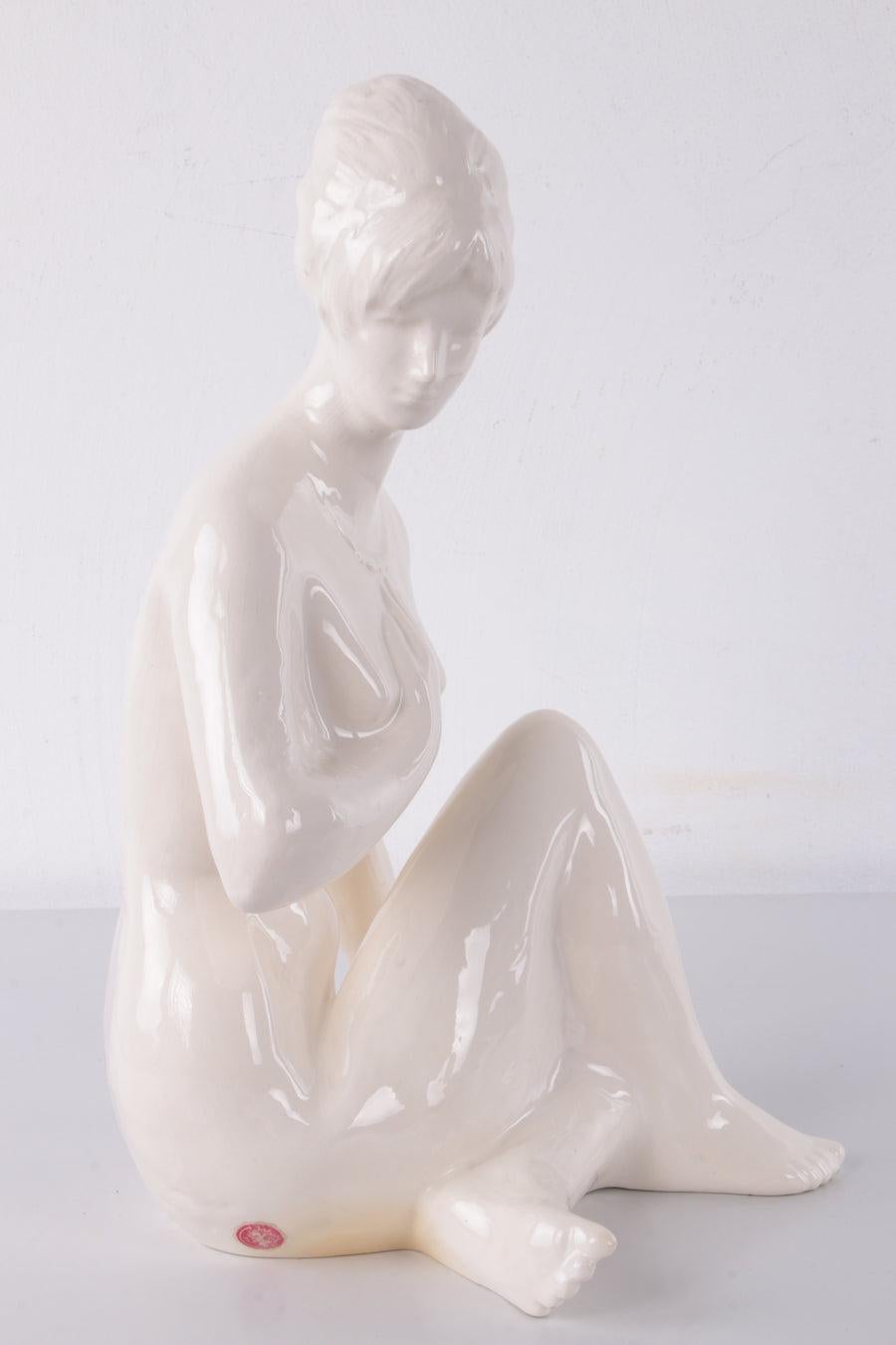 White Female statue made of ceramic around 1960

This is a beautiful white ceramic female figure sitting charmingly with her legs crossed.

Presumably made in Germany in the 1960s.

No chips or damage, so in nice condition.

Additional information: