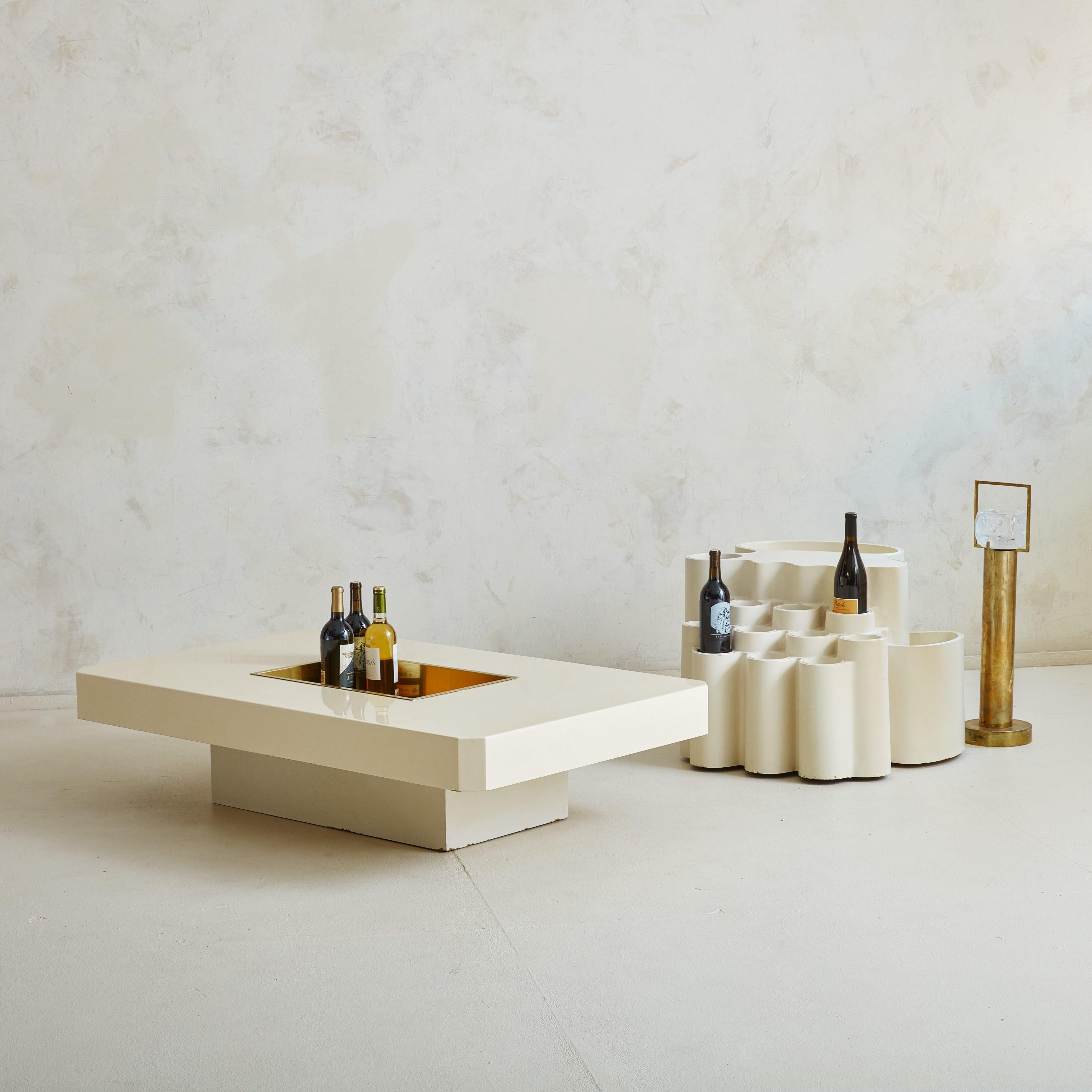 A 1970s Italian planter or bar cart composed of fiberglass in an off-white hue. This sculptural piece features hollow cylinders of varying heights arranged in artful tiers. The base is supported by wheels, allowing for easy mobility. It makes a