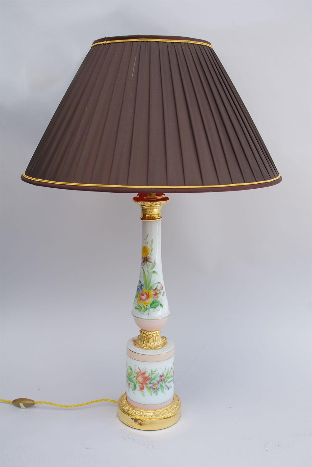 Bottle shaped on a cylindrical base white porcelain lamp in Paris Porcelain wares.
Decoration of pink banners framed with gilt highlights and different kinds of flowers such as roses, peonies, bellflowers etc.
Gilt bronze mount adorned with acanthus
