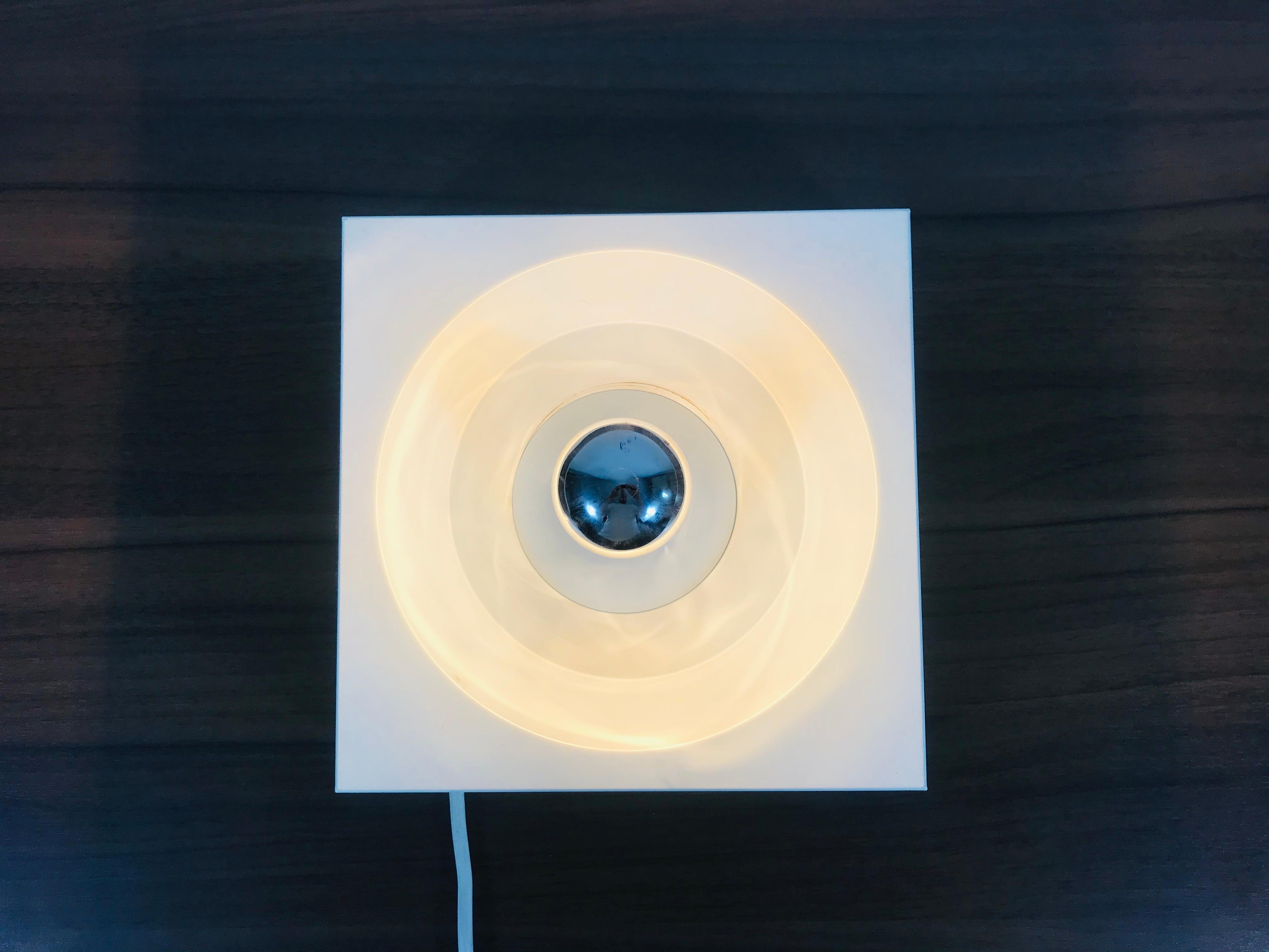 A Space Age flush mount or wall lamp by Kaiser made in Germany in the 1970s. It was designed by Klaus Hempel. The body of the lamp is made of full metal and has a beautiful white color.

The light requires one E14 light bulb.