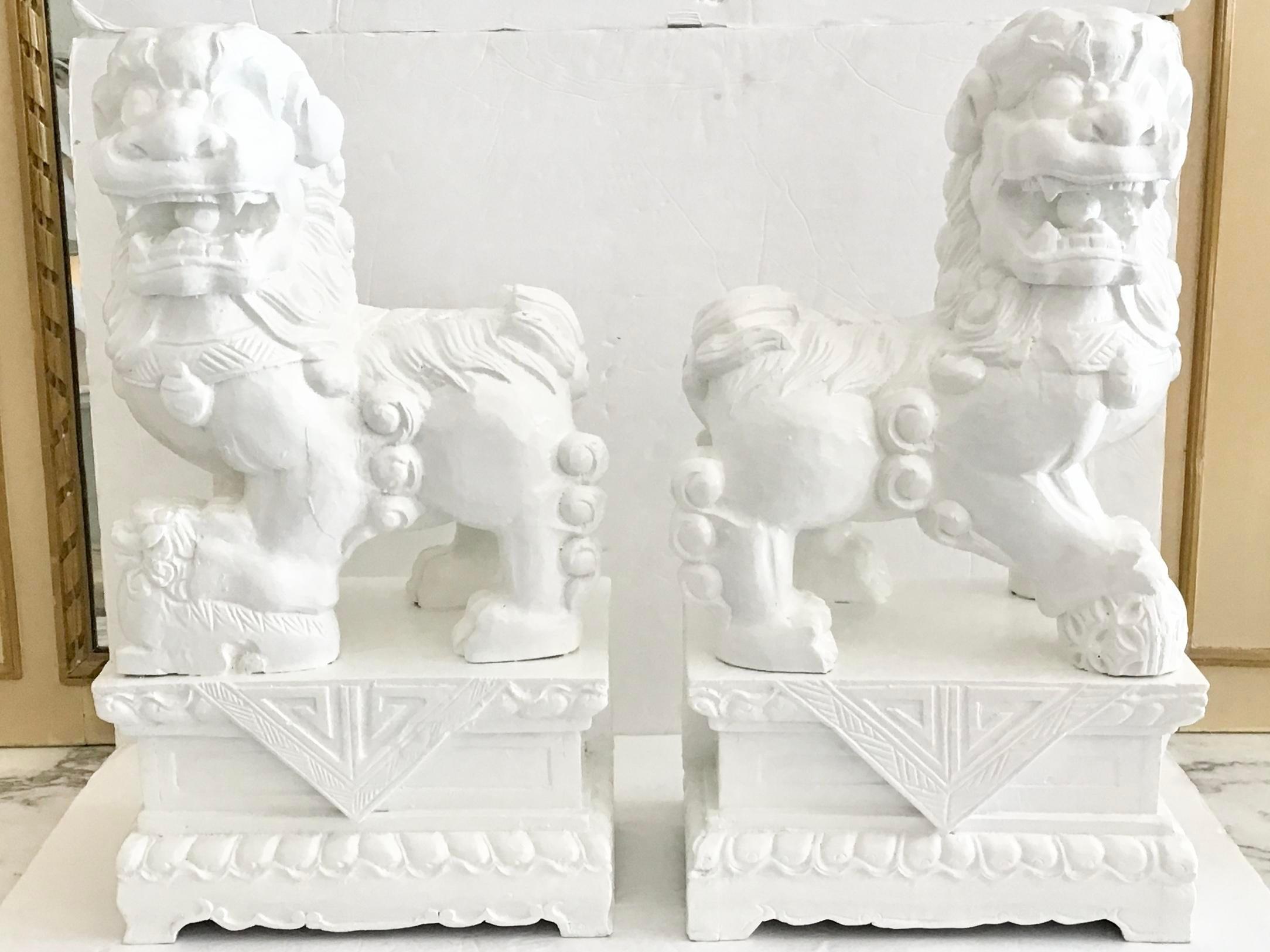 Pair of freshly lacquered in white fantastic large foo dogs made of wood. The geometrical carving details at the base is amazing. Add it to your collection of Asian art.