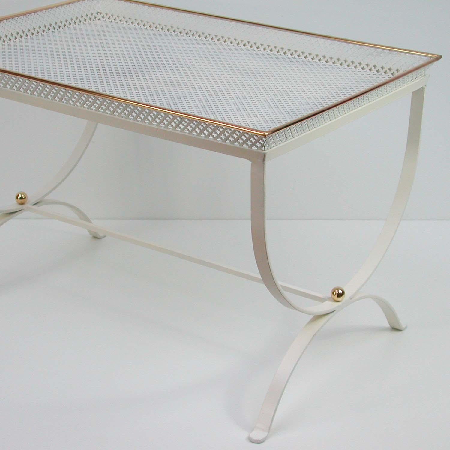 This 'Snow White' side table was designed and manufactured in France in the 1950s. It is made of white lacquered perforated metal and brass details in the manner of Mathieu Matégot.