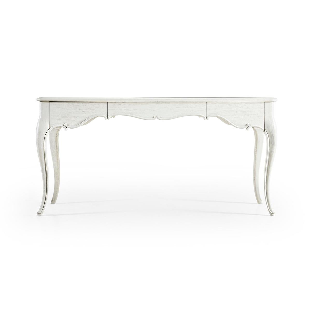 A central drawer featuring touch-latch technology effortlessly opens to a leather-lined interior with built-in pencil tray for organized storage. The chalk-white finish is amplified with light distressing for a hint of rustic charm that pleasantly