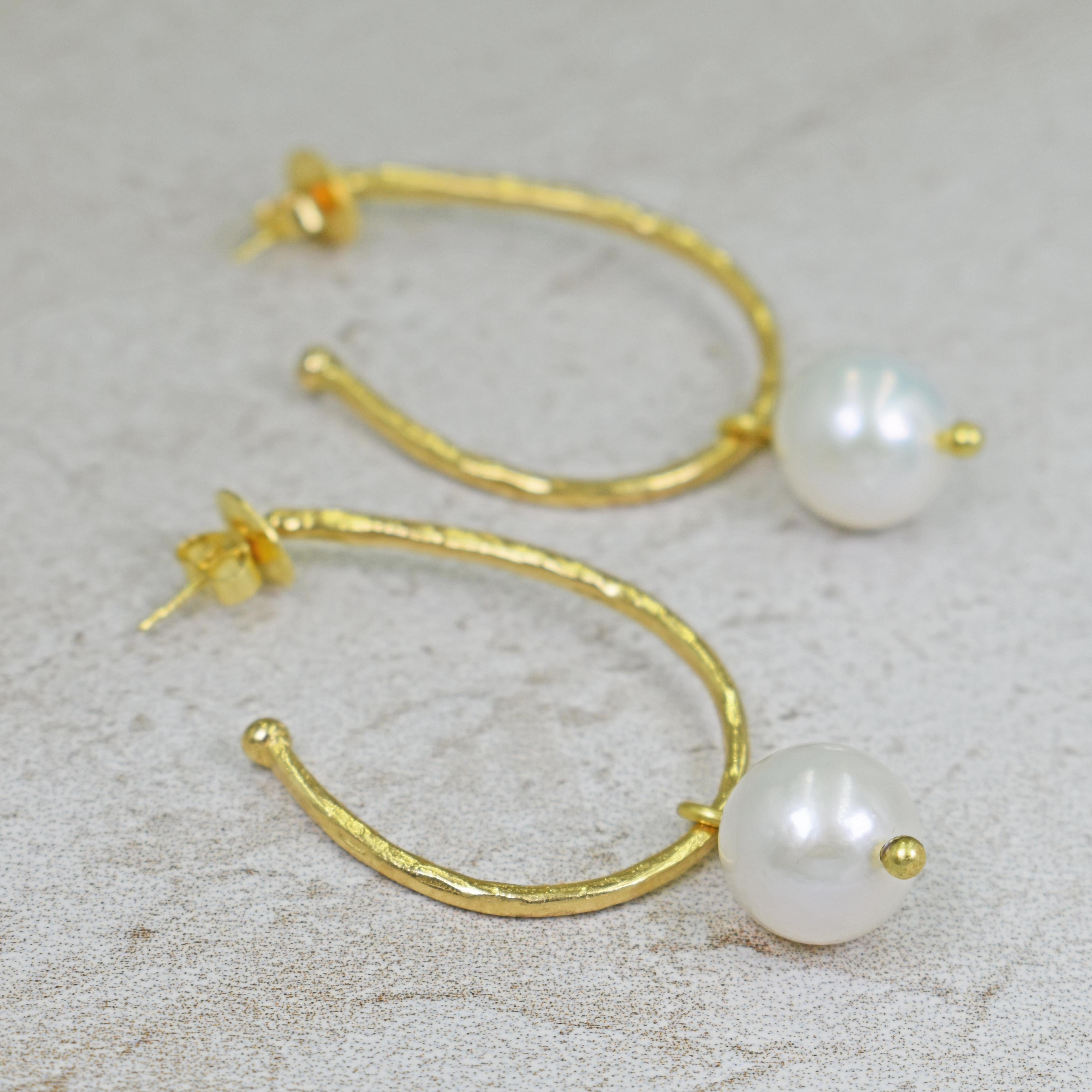 Hammered 18k yellow gold elongated hoop stud earrings with 13mm White Freshwater Pearl charms. Hoop earrings are 1.63 inches in length, and with pearl charms, earrings are 2.32 inches in total length. Charms can be removed so the hoops can be worn