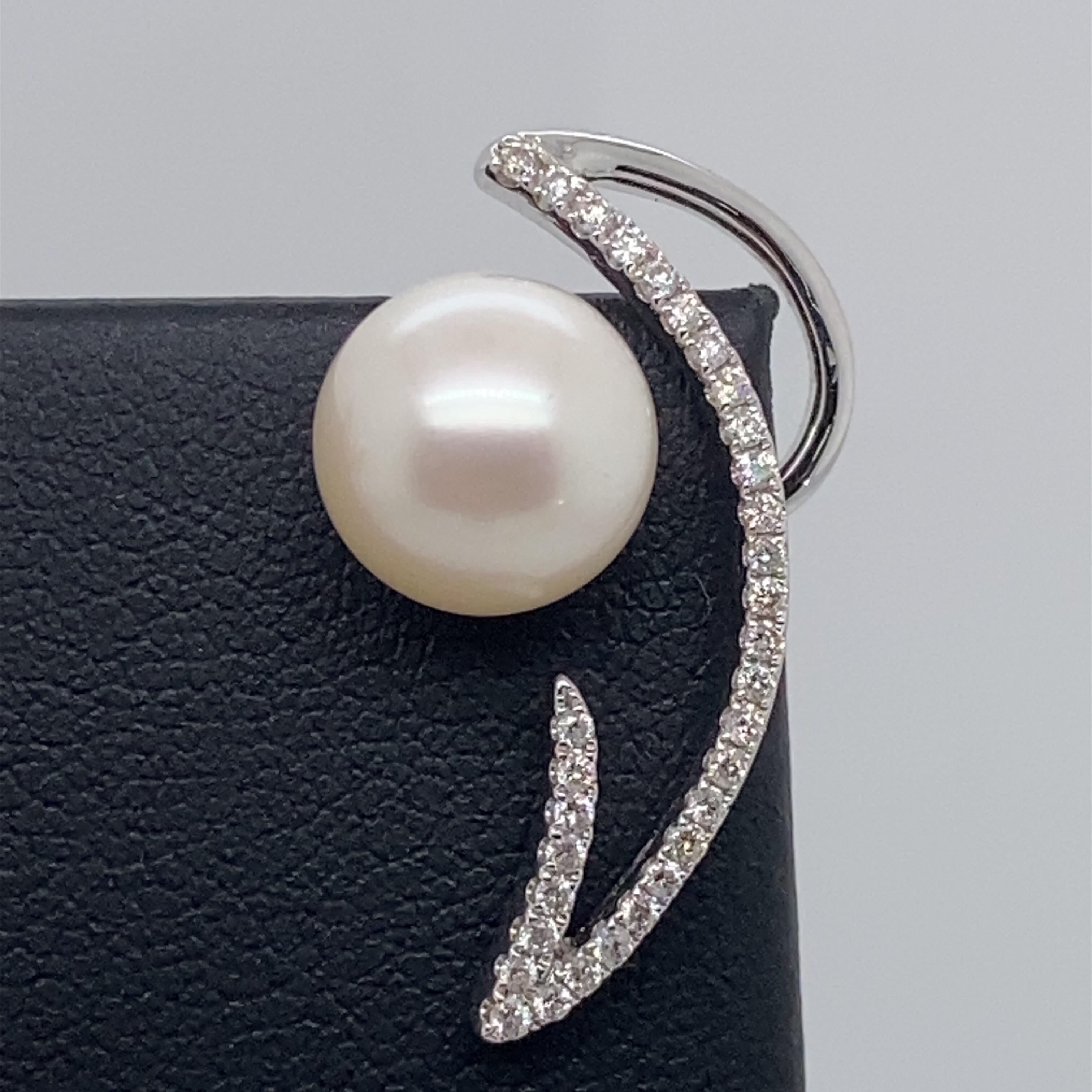 14K White gold drop earrings featuring two Freshwater pearls measuring 9-10 mm flanked with round brilliants weighing 0.36 carats. 
Color G-H
Clarity SI