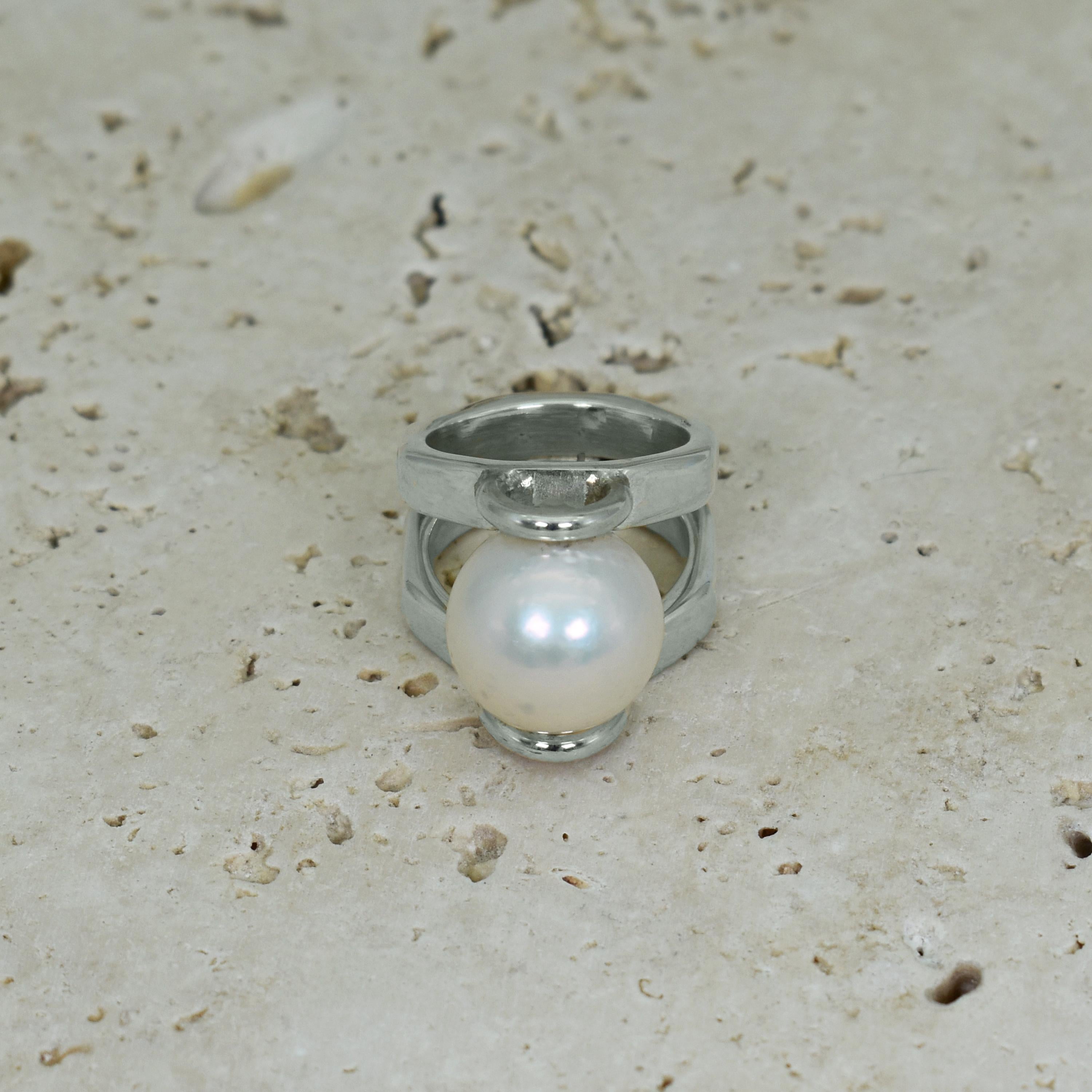 Perle d'eau douce blanche de 14 mm sertie dans une bague cocktail en argent sterling à tige fendue de forme octogonale. La bague est de taille 6. Bague unique et contemporaine avec une perle intemporelle.