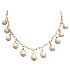 Weiße Süßwasserperlen baumeln an einer Kette aus 14k Gelbgold Paradizia Halskette