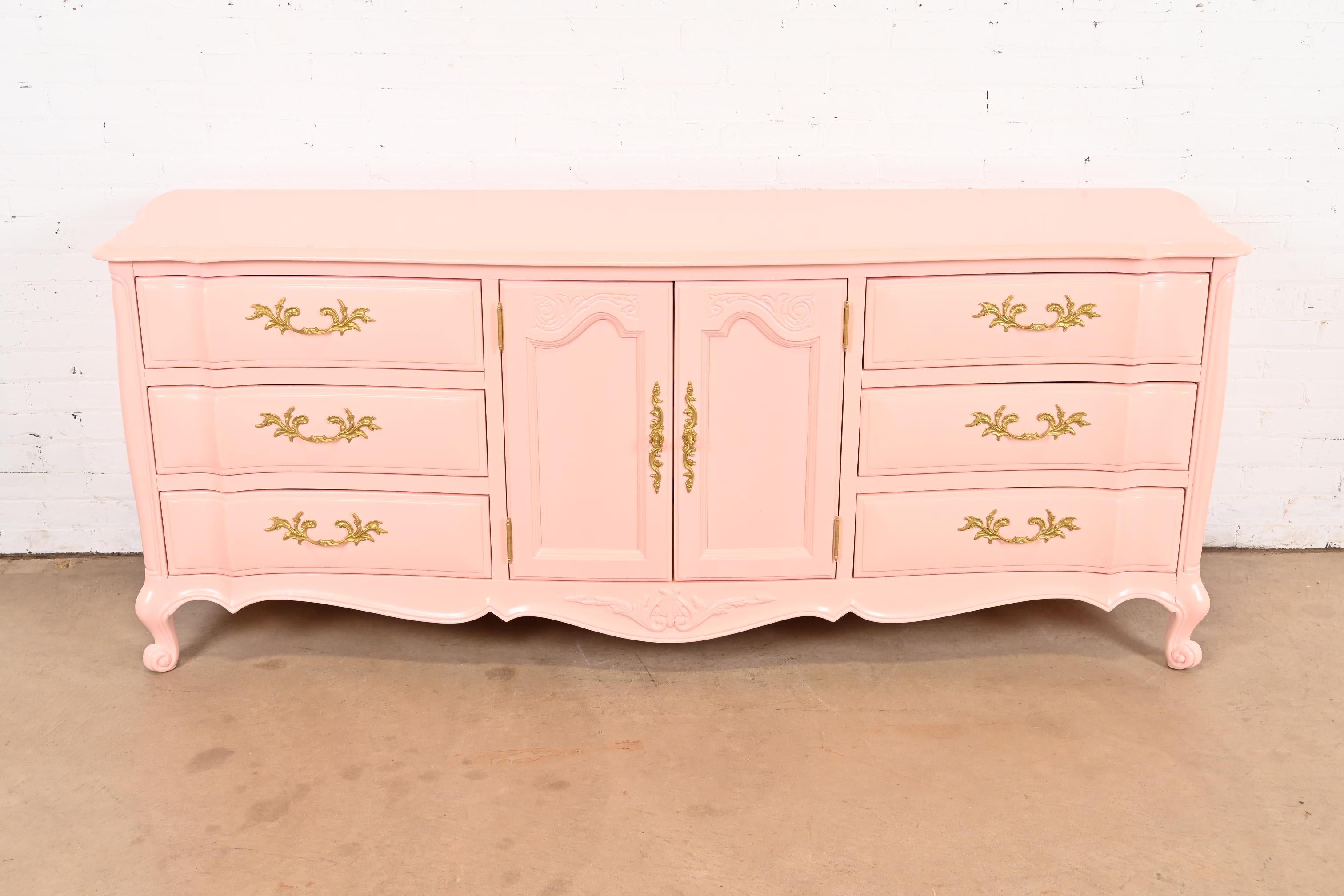 A gorgeous French Provincial Louis XV style long dresser or credenza

By White Furniture

USA, Circa 1960s

Pink lacquered solid cherry wood, with original brass hardware.

Measures: 82