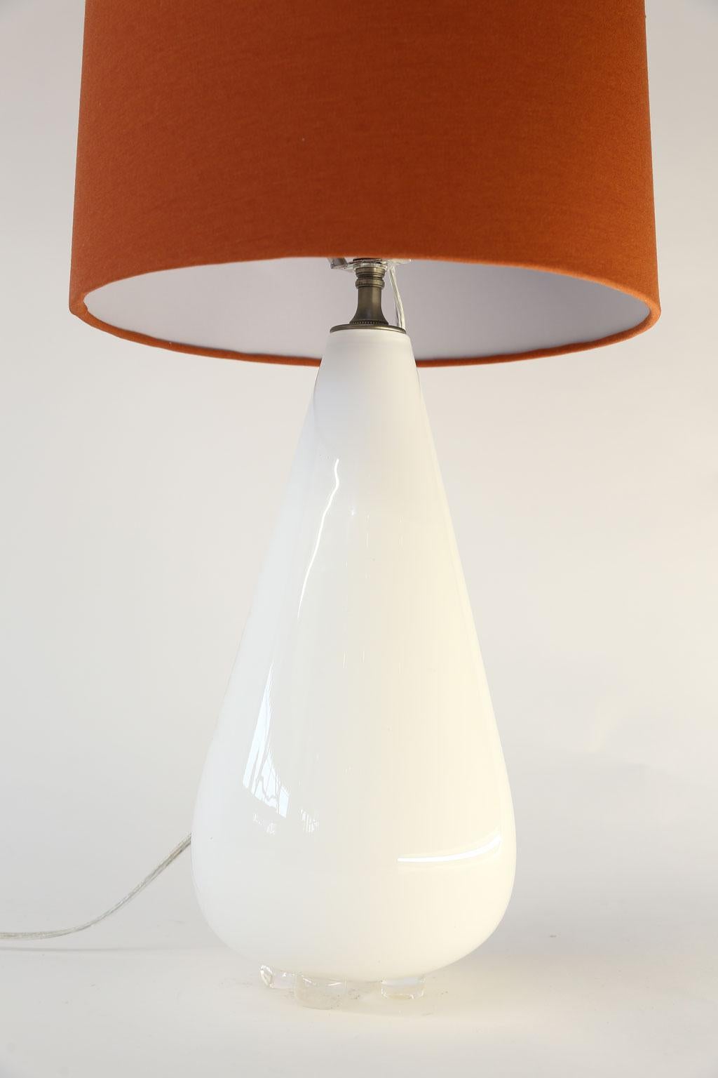 White cased glass table lamp from hand blown cased-glass footed vase. This custom fixture is newly-wired for use within the USA and includes a complementary reddish-clay color linen shade (lamp measurements include the shade).

