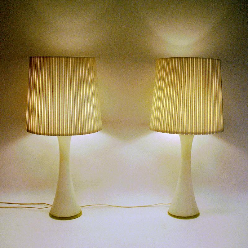 Elegant pair of white glass tablelamps by Bernt Nordstedt for Bergboms AB Sweden in the 1960s. Diabolo shaped and with teak lids on top. Marked with makers mark underneath: Bergboms. 
Measures: Height about: 45 cm H. (incl bulb socket) Lampfoot 15