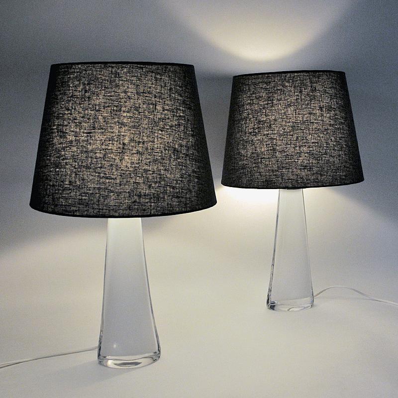 Lovely midcentury pair of white glass table lamps model RD1566 designed by Carl Fagerlund for Orrefors Glass, Sweden 1960s. Inner white crystal glass core surrounded by a clear glass cover. metal details on top. The lamps are heavy with elegante
