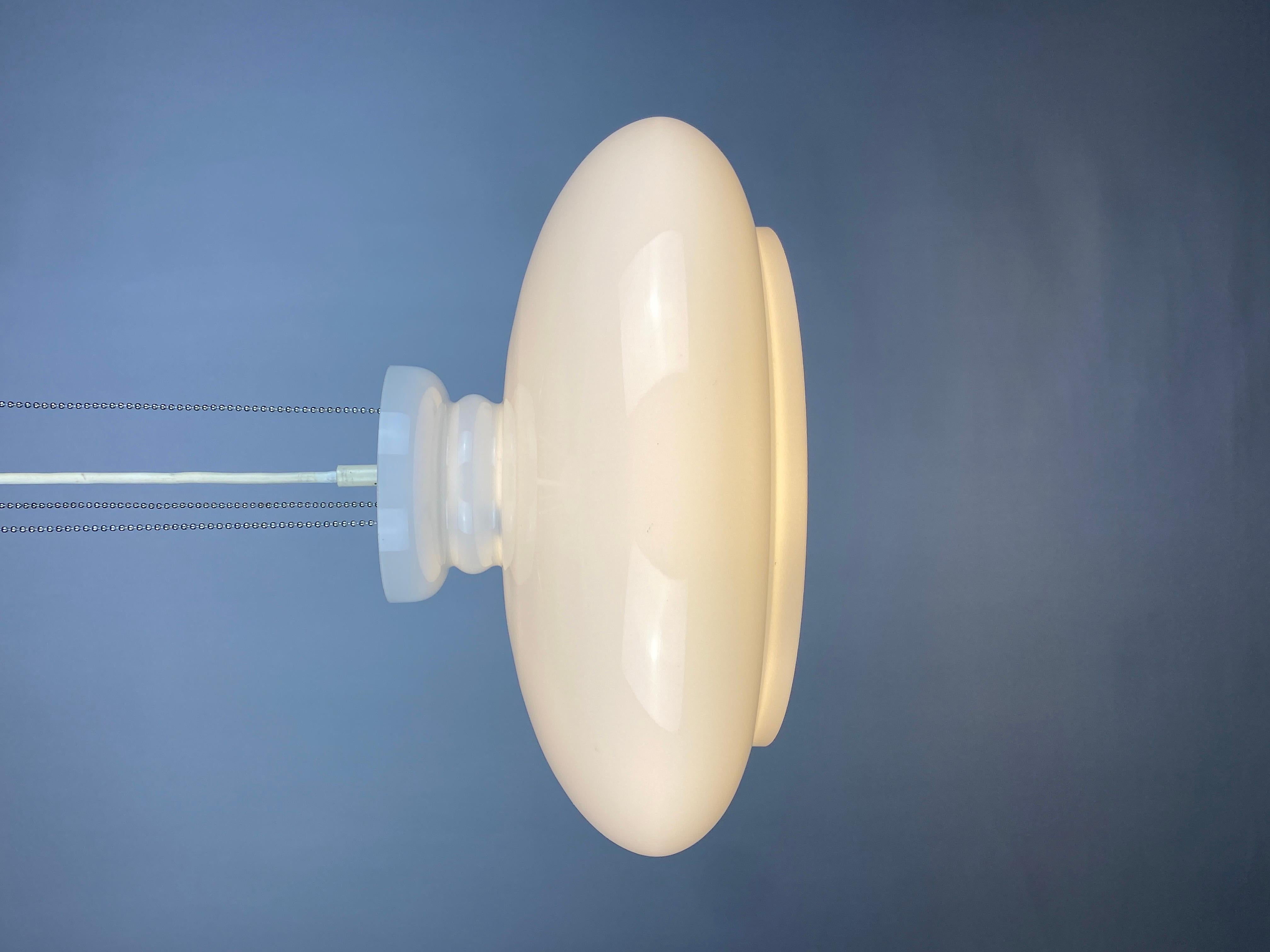 Cool UFO looking white glass pendant light by RAAK Amsterdam from the 1960's. This model is called B-1008 BOWL. 

In an early RAAK catalog (see photo) you will find this lamp as Type B-1008. Later he gets the addition B-1008 BOWL or bowl scale.