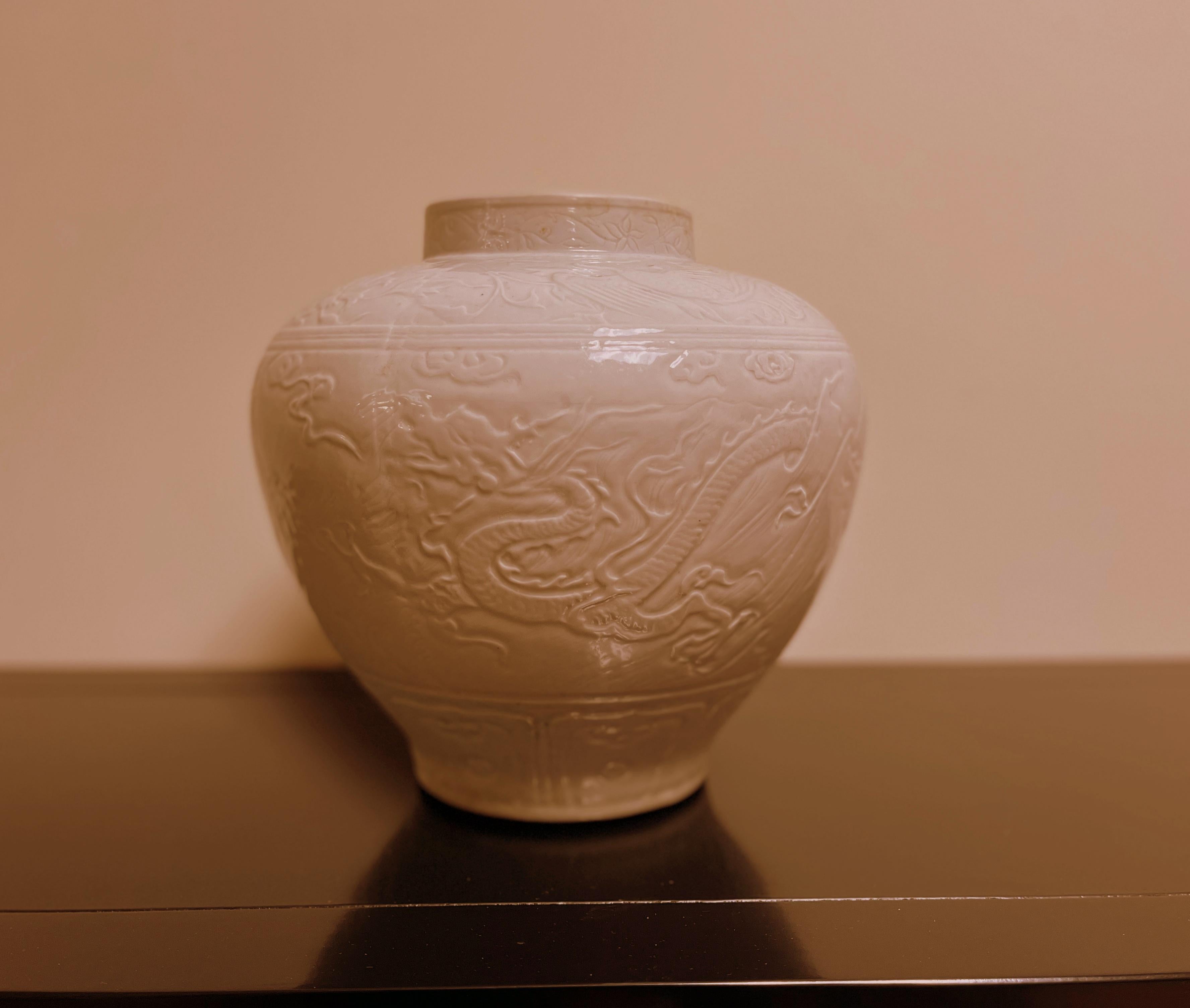 White glaze porcelain jar with dragon motif. 
Dimension:  the widest diameter in middle part is  10.8