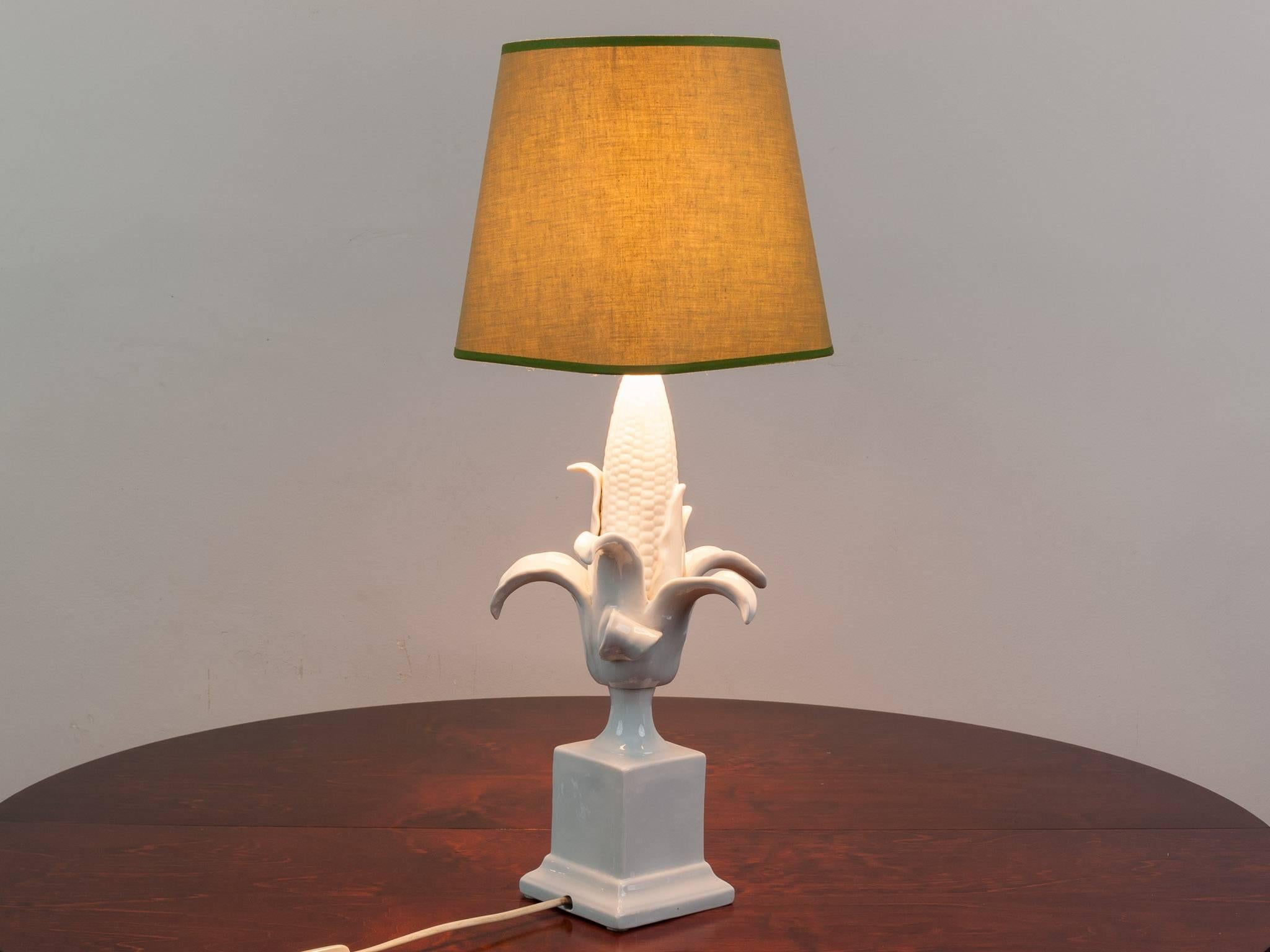 An unusual and quirky 1970s white glazed porcelain table lamp in the shape of a corn on the cob including its original pale green shade. Unknown designer. PAT tested to UK standards.

Measures: 46cms to the fitting. 63cms to the top of the shade.