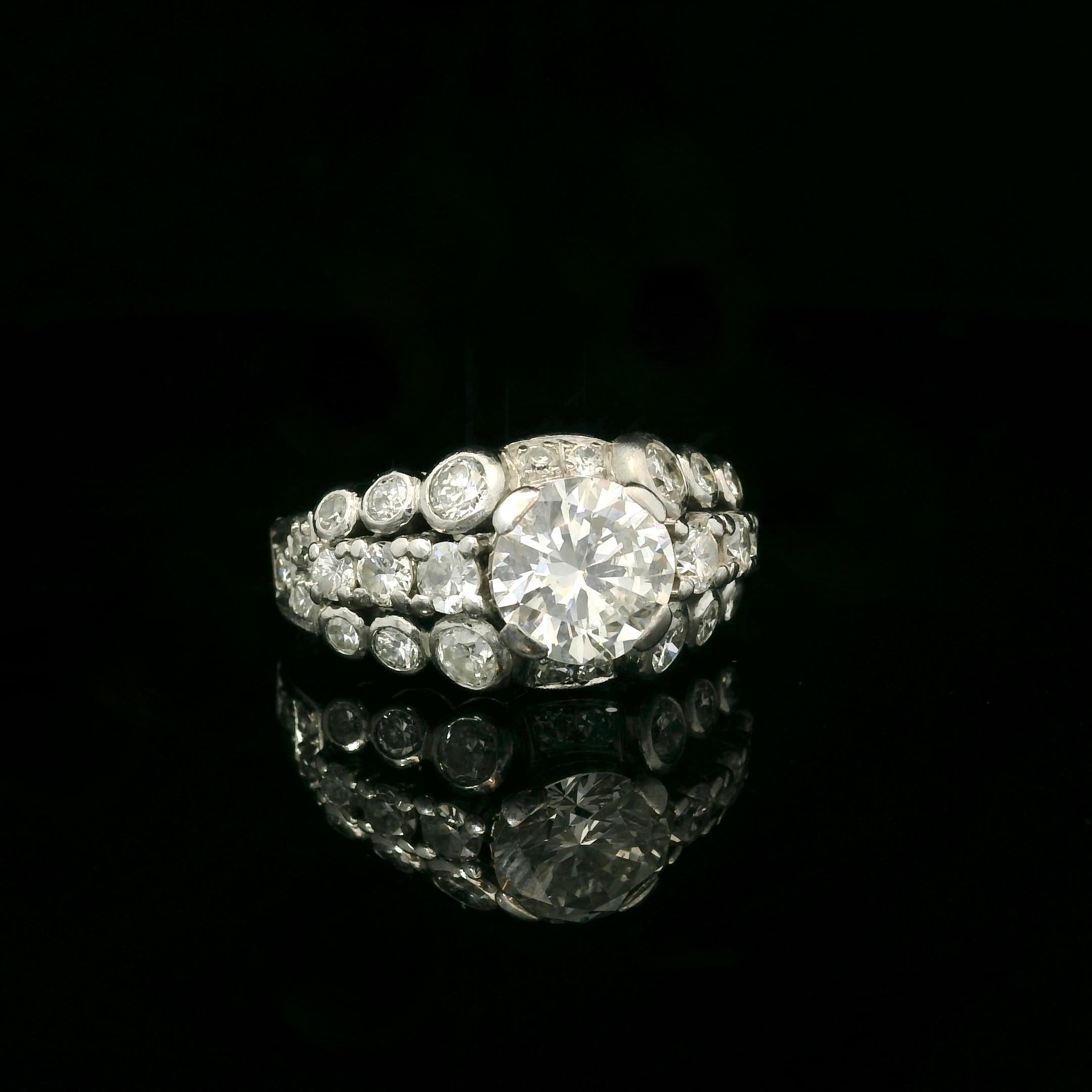 White gold 18 Karat ring from 1951. 

The ring is set with a center brilliant diamond of 1.30 Carats (estimated H color - Vs clarity) and approximately 0.65 Carats 8/8 cut diamonds. All the diamonds are bright and lively. 

Weight: 6,6 grams. 

The