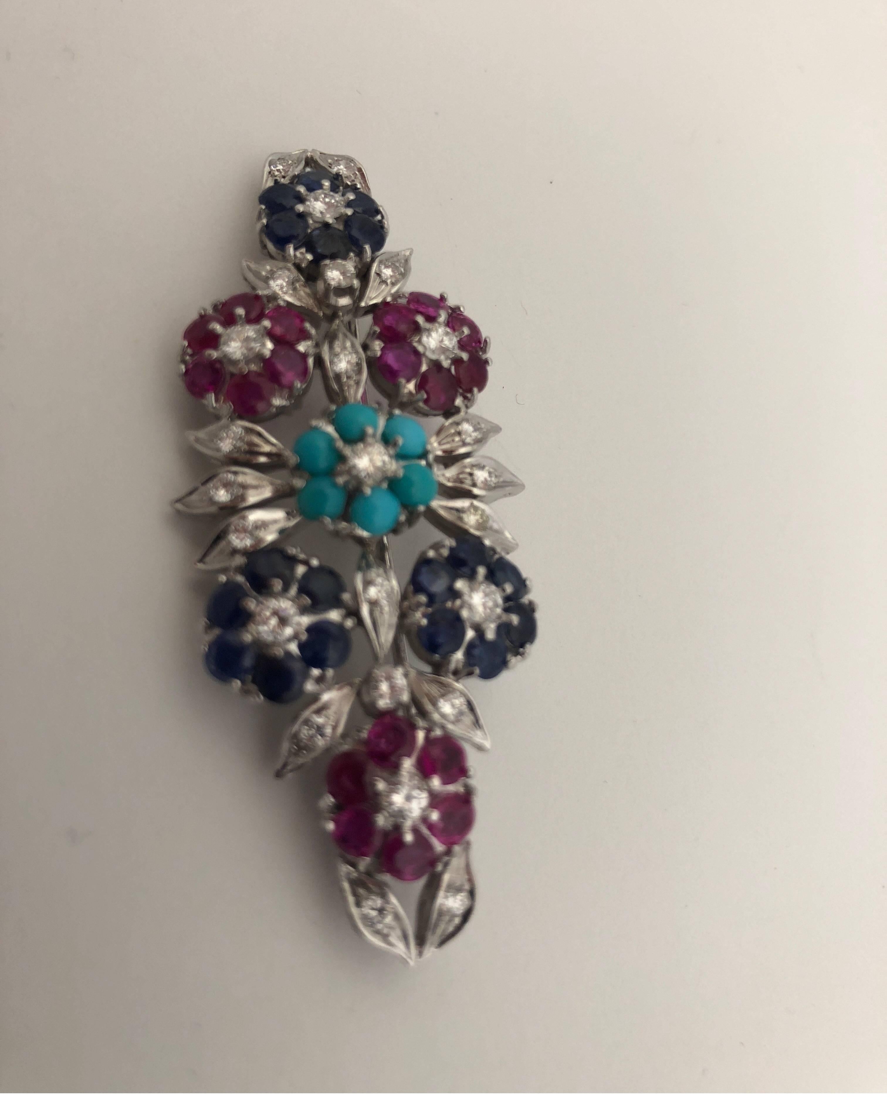 White gold 18 kt brooch with white diamonds, blue sapphire, ruby and turquoise
total weight of gold gr 16.50
total weight of diamonds ct 1.80
total weight of ruby ct 2.47 
total weight of blue sapphire ct 2.70
total weight of turquoise g 0.15
STAMP