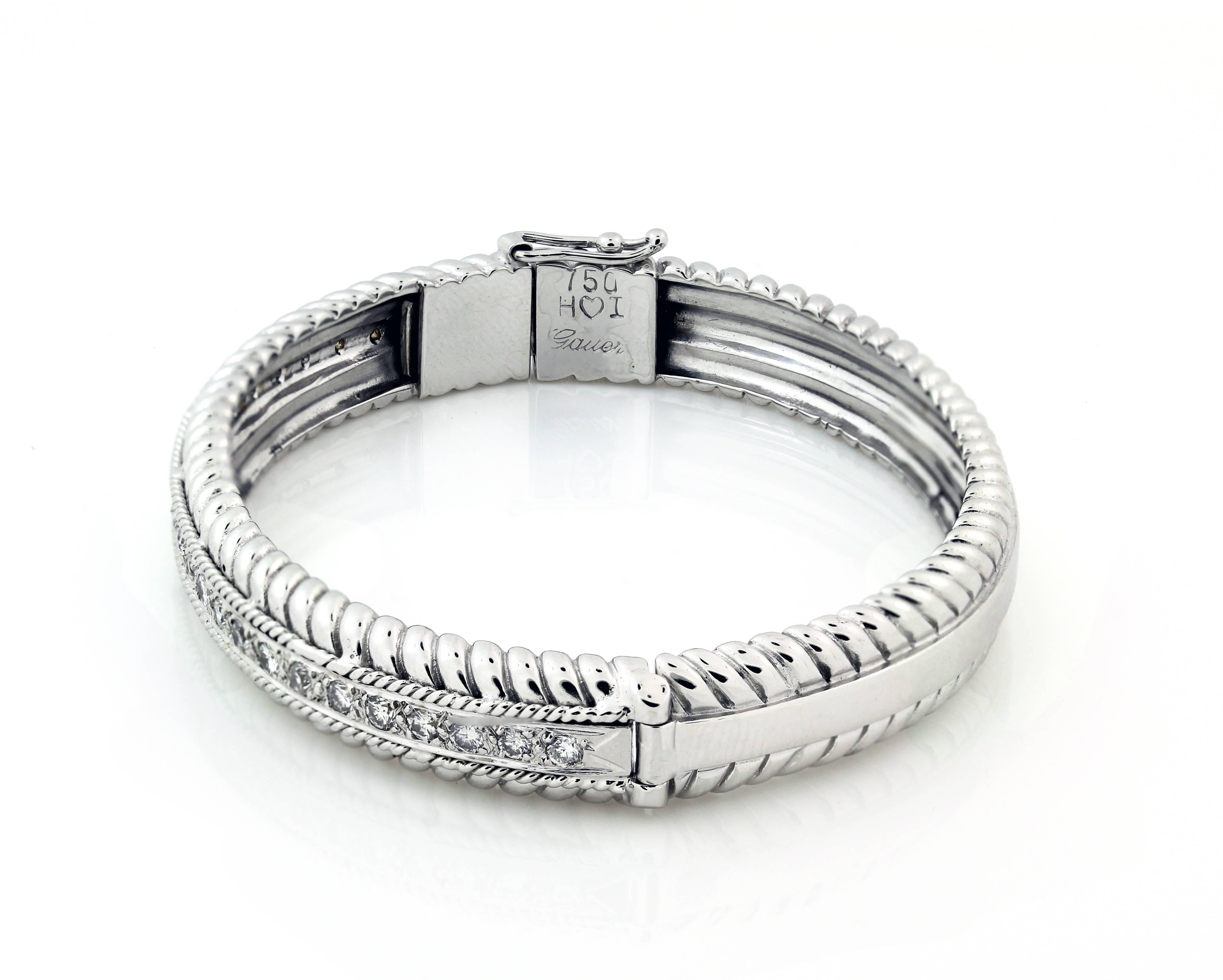 18K White Gold bangle bracelet with diamonds 

Diamonds are set on one side with gorgeous design work seen all throughout.

Apprx. 0.78 carat H color, SI1-SI2 clarity diamonds 

Bangle is a size 7 and 0.3 inch width.

Push button, hinge used to lock