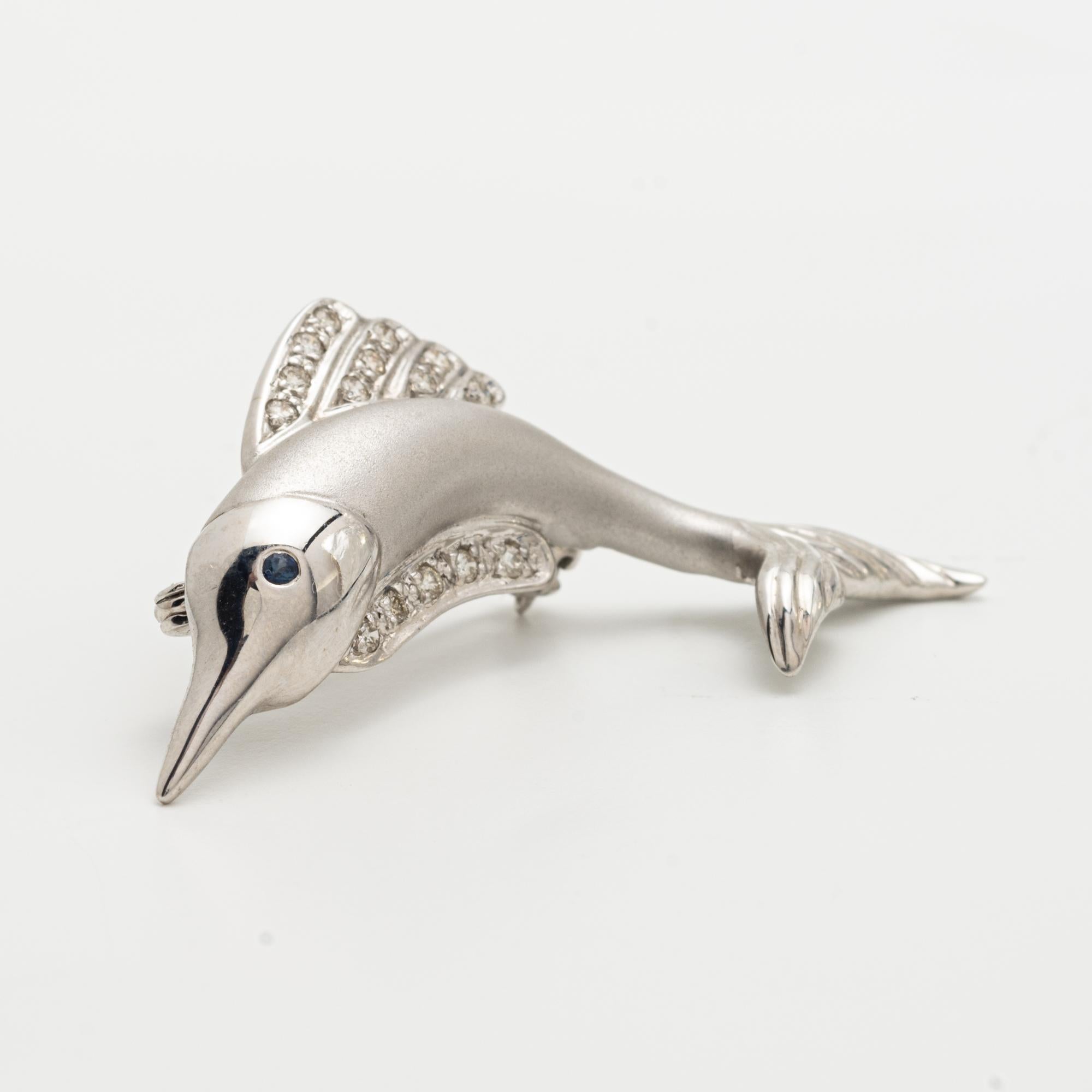 
White Gold and Diamond Fish Brooch 
14 Karat Gold and Diamond Fish Brooch, the fish set with numerous diamonds, with a colored stone eye, 1.56 inches
