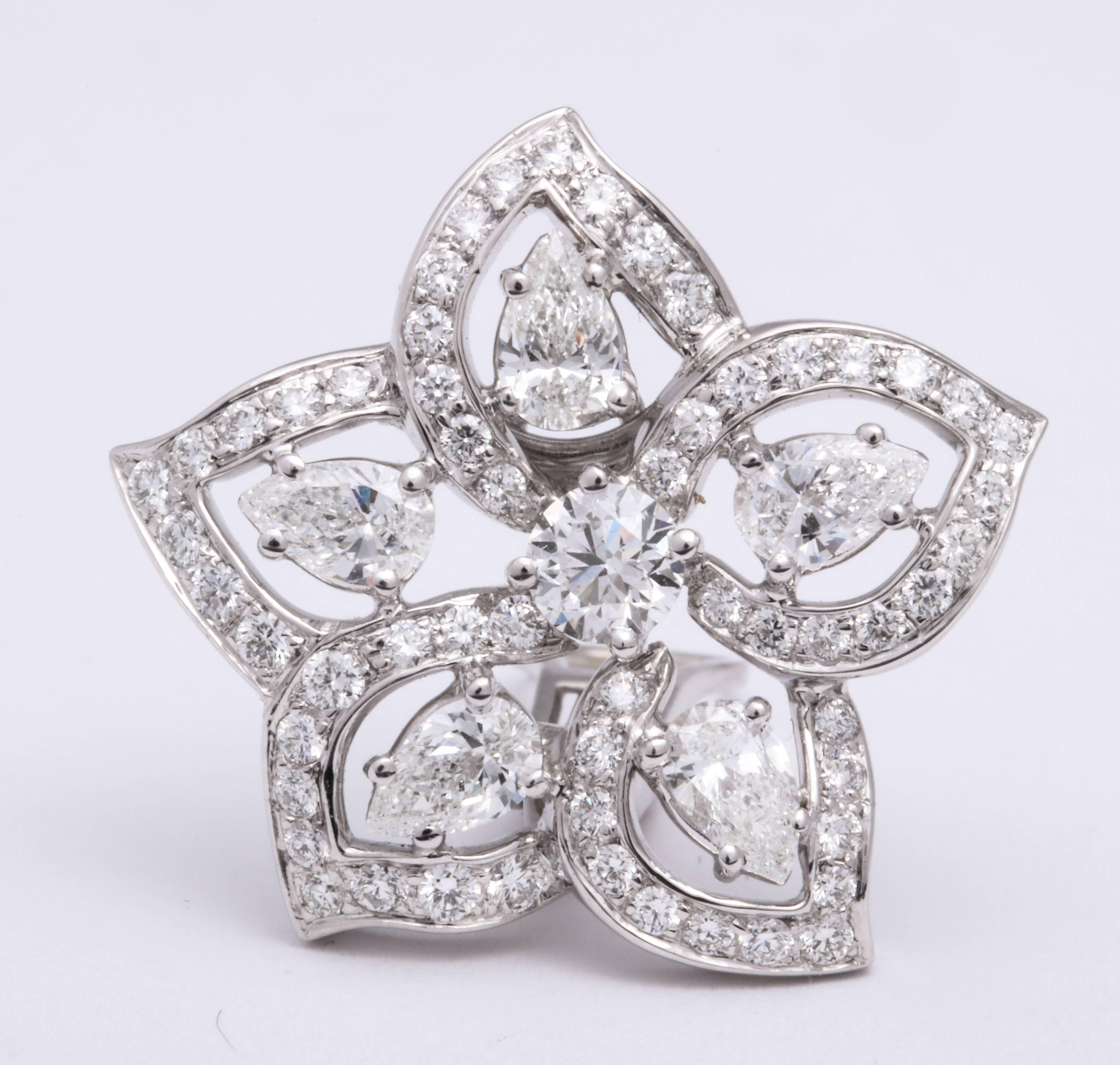 Romantic 18 Karat white gold 5-petal floral earrings mounted with floating pear-shaped diamonds within a trim of pave'-set round brilliant-cut diamonds, total weight: 3.82 carats.  Fitted with French clip and post for pierced ears.  Can be worn with