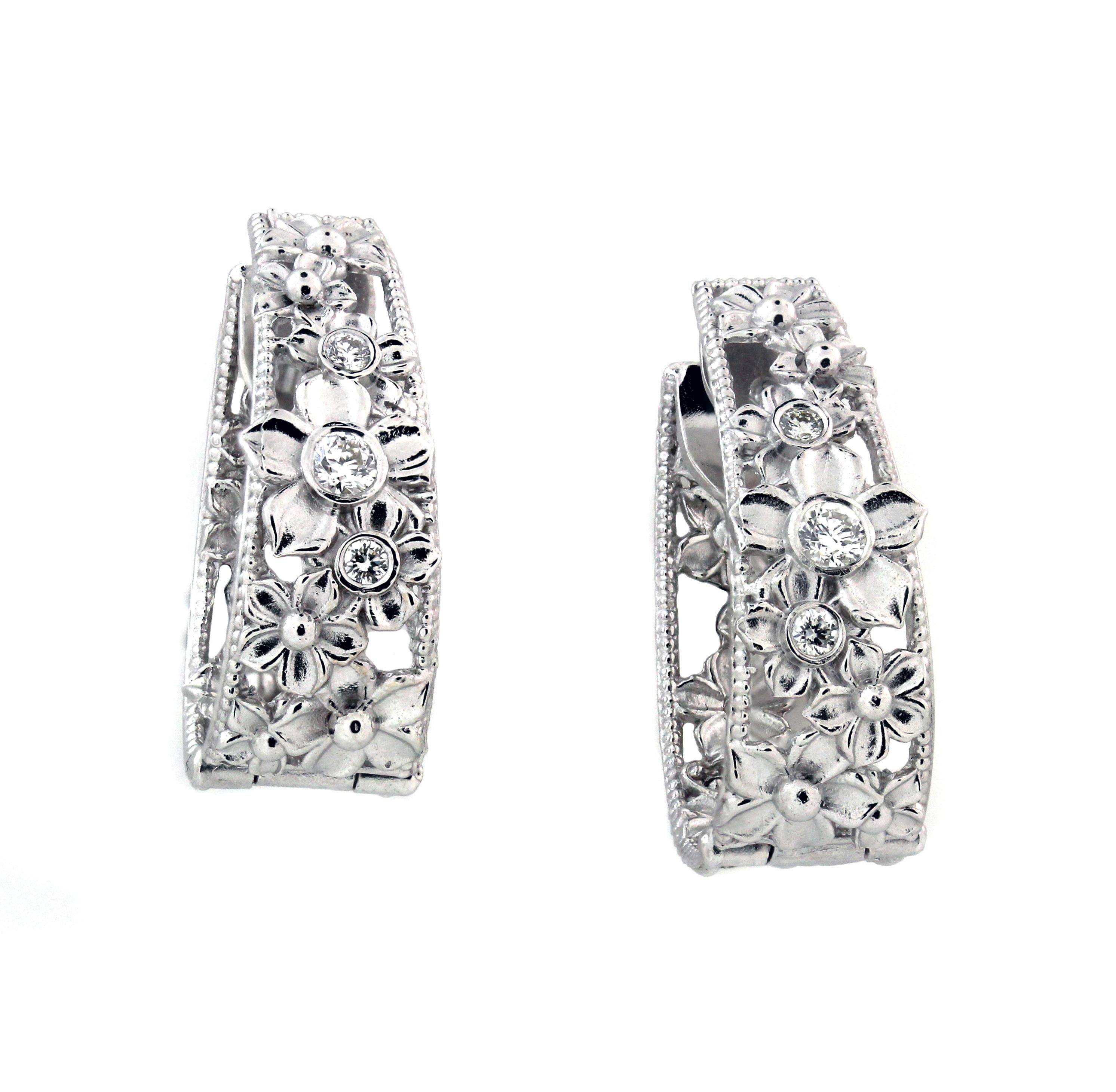 18K White Gold and Diamond Floral Hoop Earrings by Stambolian

These are inside-out earrings with diamonds set on face of earrings and floral design continuing on the interior.

0.34ct. G color, VS clarity diamonds. 6 total stones.

Earrings are 1