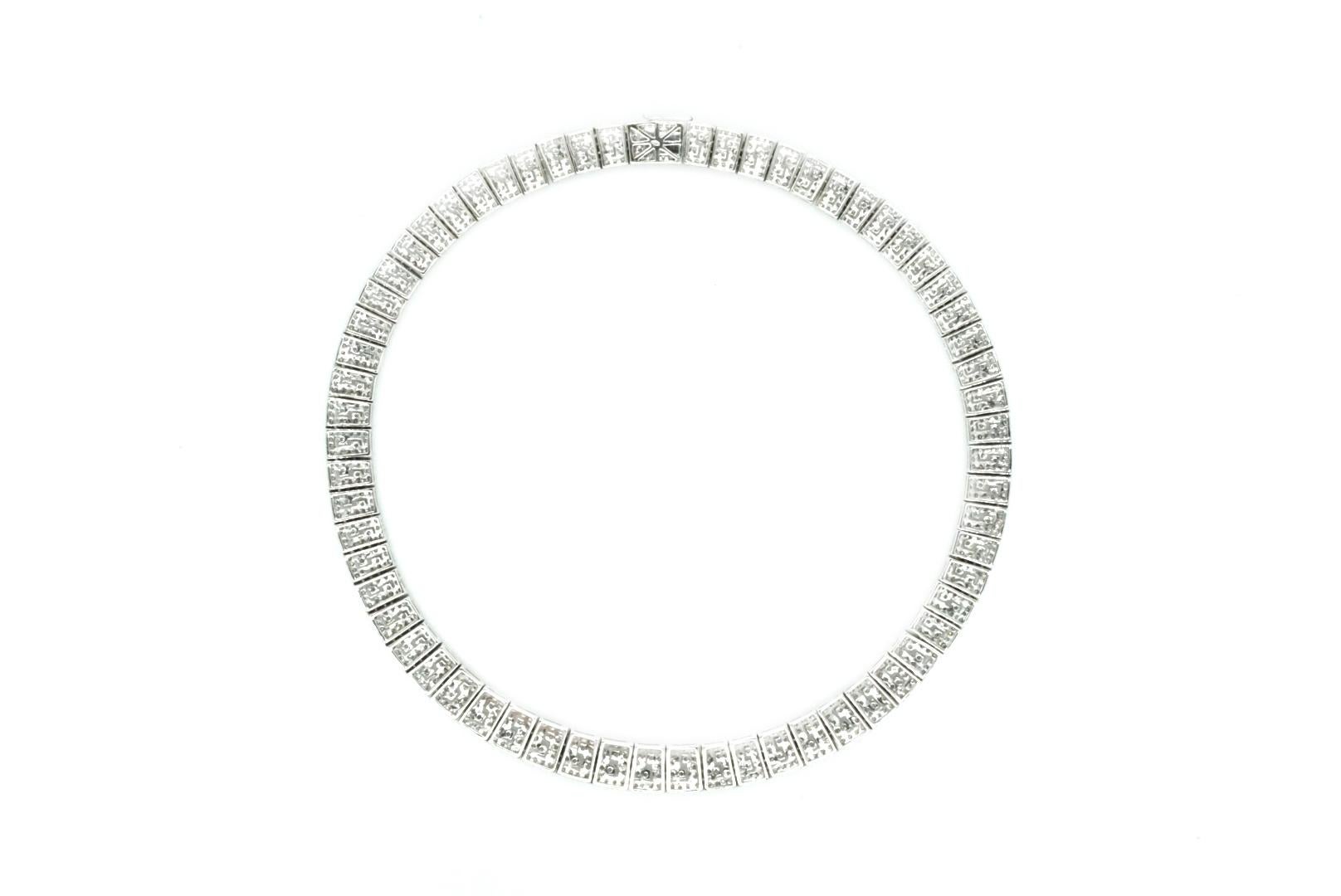 An 18kt White Gold and Diamond Necklace. Round diamonds weighing ap. 14.60 cts. Length 16 5/8 inches. Made in the USA, circa 1950.

Width 7/16 to 3/8 inch. 