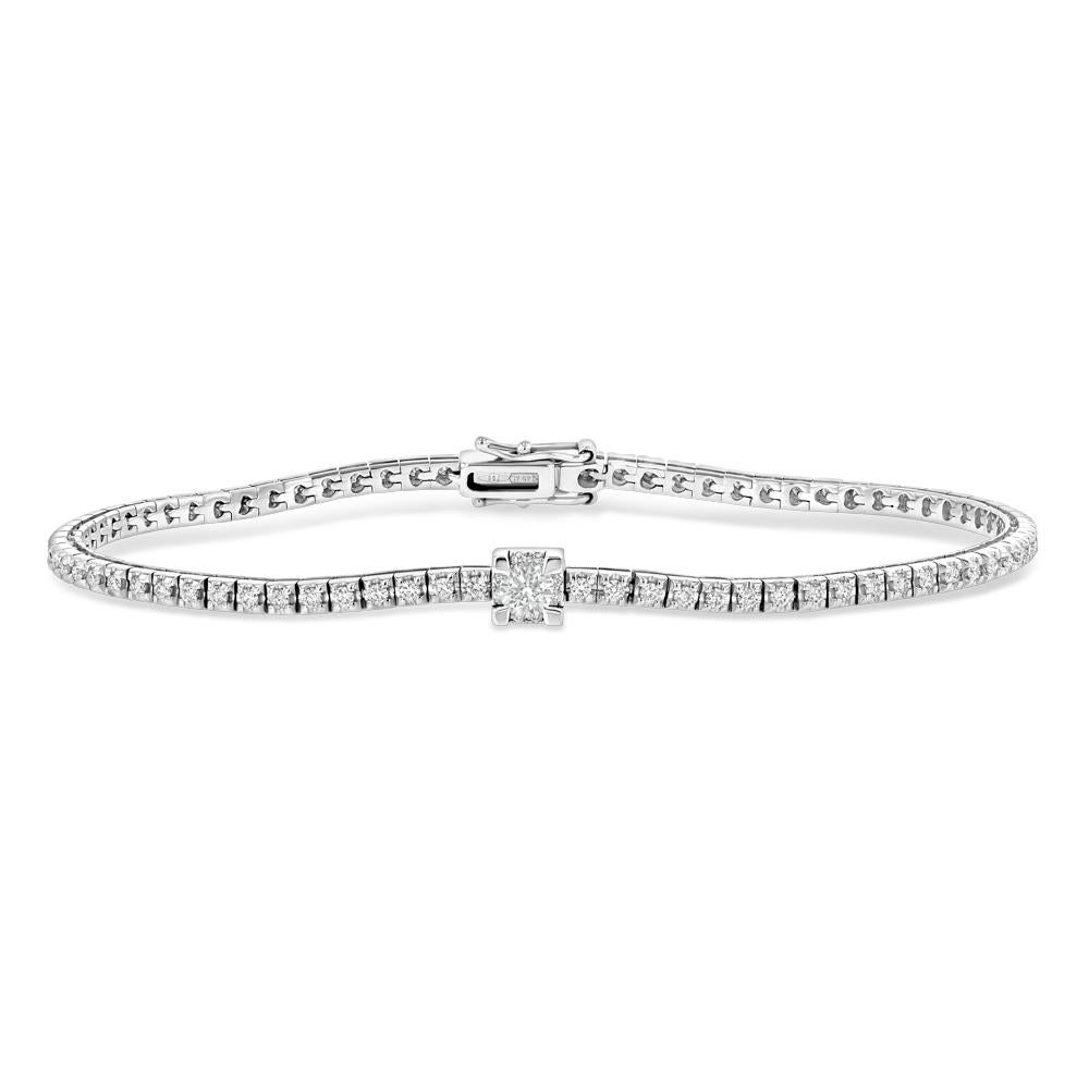 This stunning and unique white gold tennis bracelet holds 79 diamonds. While the majority of the diamonds lie in the same plane, one larger stone sits in a raised center set place on the piece making for a unique twist on the beloved classic.