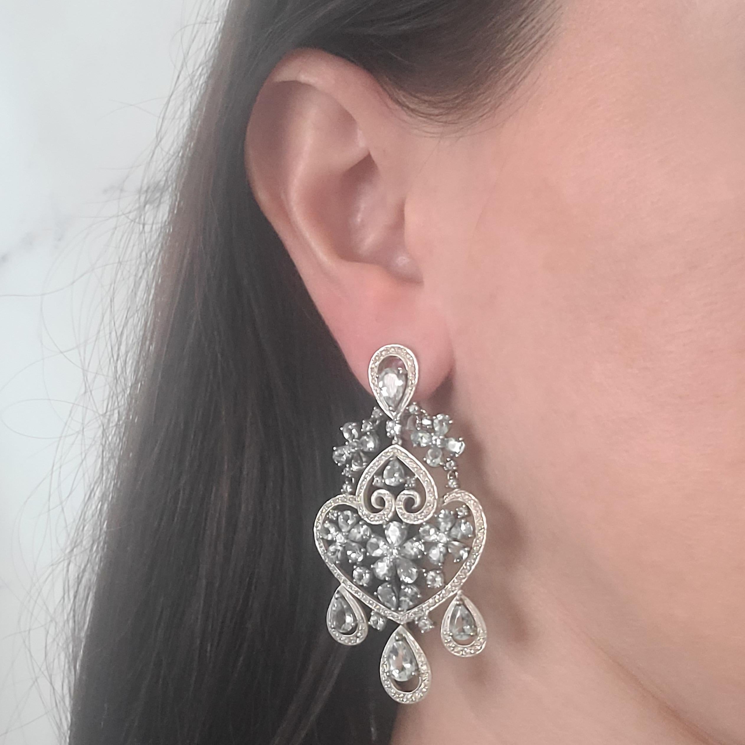 18 Karat White Gold Chandelier Earrings Featuring 64 Pear & Round Cut Aquamarines Totaling Approximately 10 Carats Accented By 230 Round Diamonds Of VS Clarity & G Color Totaling 2.30 Carats. Omega Clip Back With Hinged Post. 2.5 Inches Long.