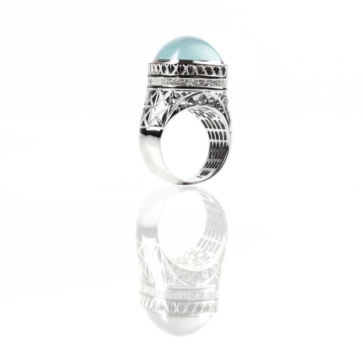 Hand made in 18 karat White Gold, this cocktail ring has a large Aquamarine Cabochon approximately 10 carats, 1.15 carats of diamonds and an intricate design to let the light through the back of the ring. Part of our Architecture Collection,