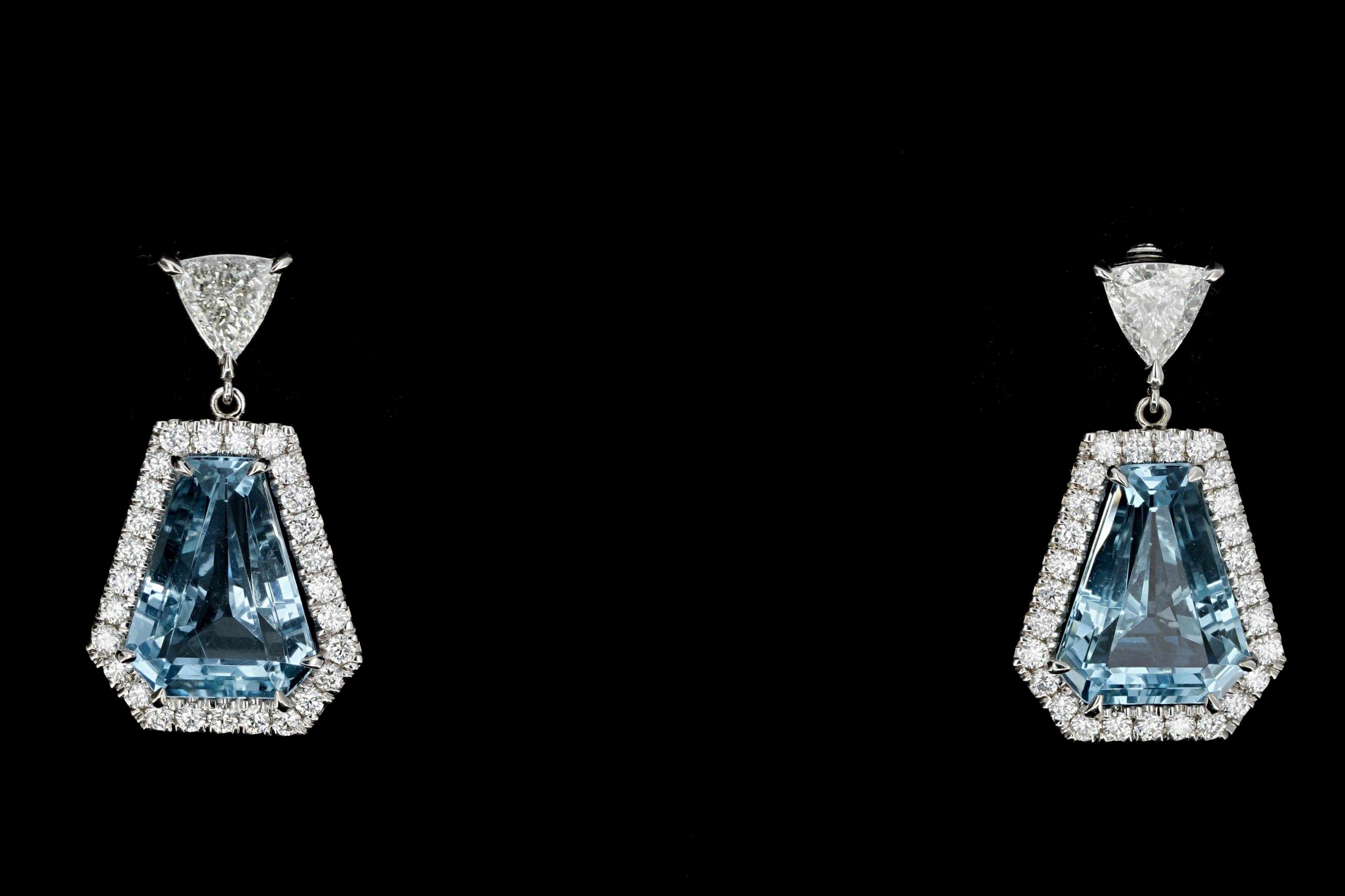 Hallmarks: 18K on earrings backs

Composition: 18K White Gold

Primary Stone: Aquamarine

Stone Carat: Approximately 9.29 carats each, 18.58 carats total

Clarity: One stone has a long string inclusion

Shape: Extra large Step Cut Shield 

Accent