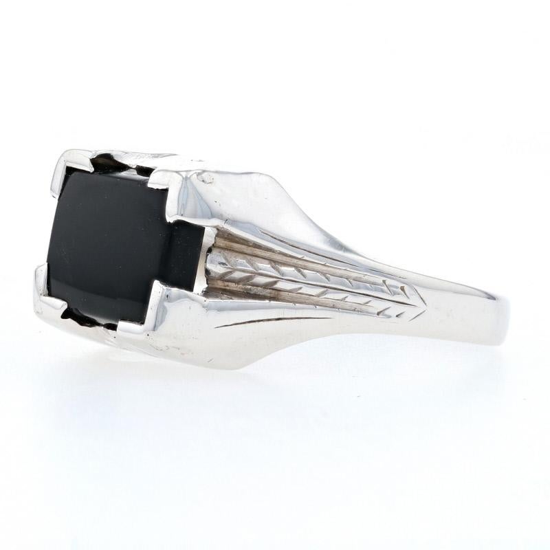 This handsome Art Deco ring from circa 1920s-1930s is fashioned in 10k white gold and features a genuine onyx in a signet-style mounting. Wheat chain detailing adds a decorative touch to the sides of the band and reveals the ring's Art Deco